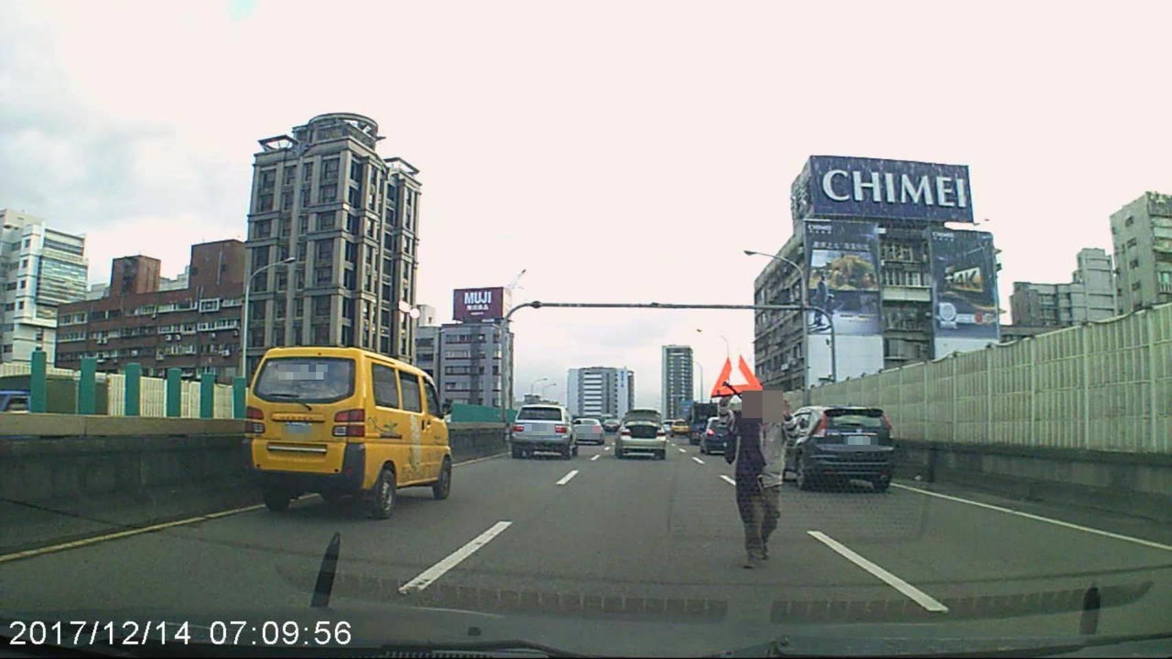 一名忘了加油的糊塗駕駛,在正值交通尖峰時間的市民大道上拋錨,駕駛拿著被撞壞的警示錐,緊張奔向警方求助。(警方提供)