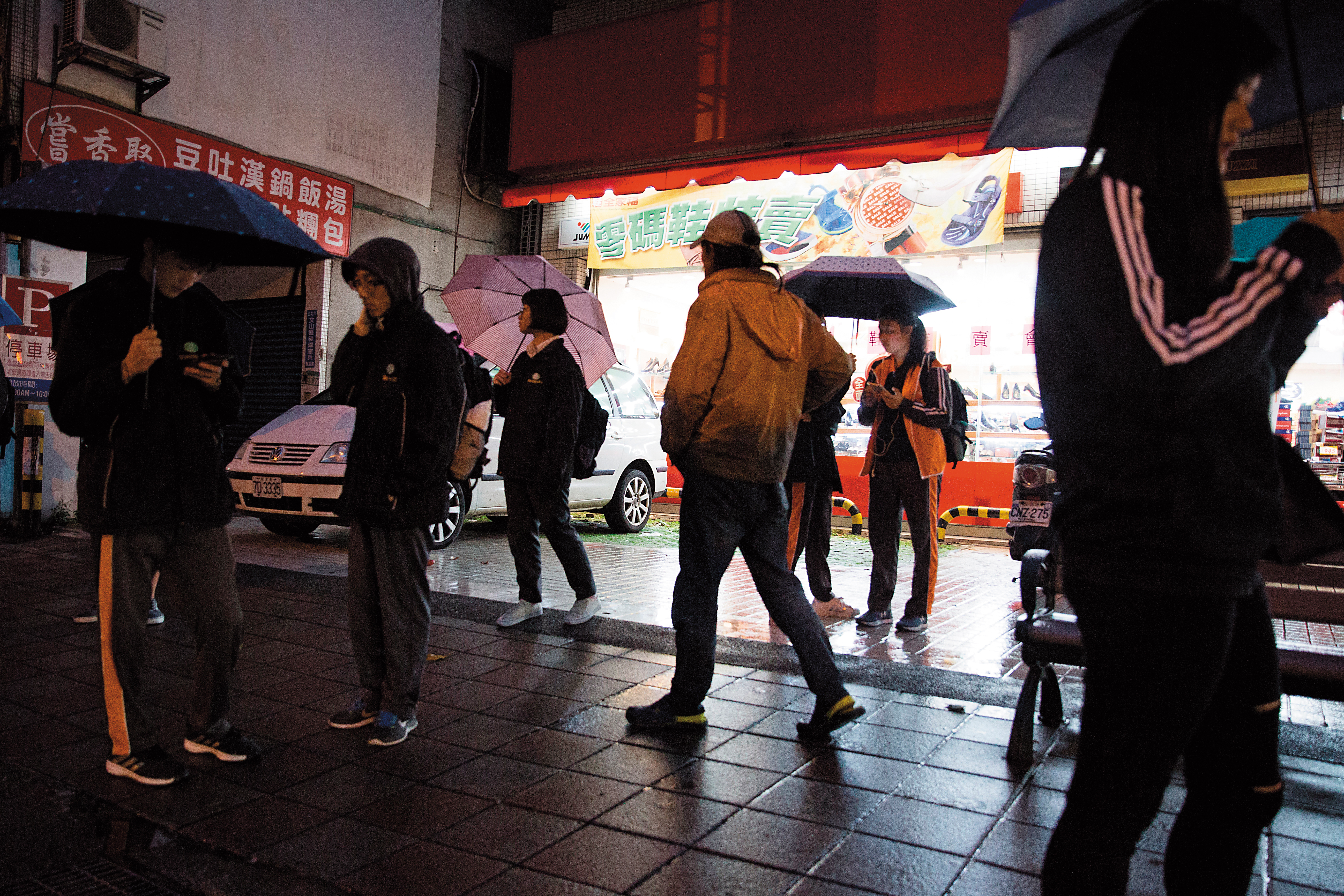 傍晚6點，搖搖哥走過木新路上的鞋店，附近的景文高中放學了，學生說，搖搖哥是常見的遊民。