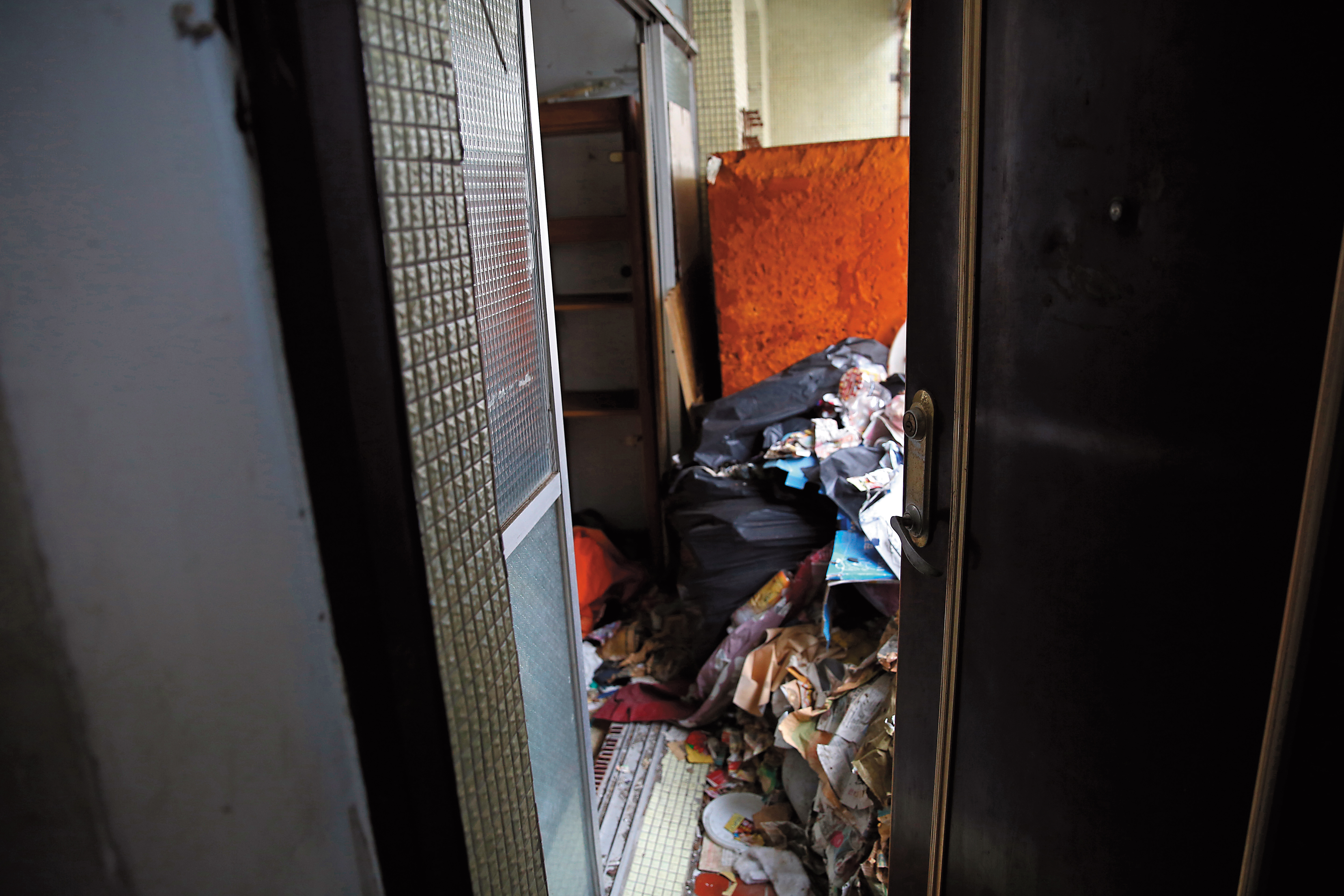 搖搖哥家的門是壞的，他出門也從不關門，在外頭就能看見裡頭堆積的垃圾。