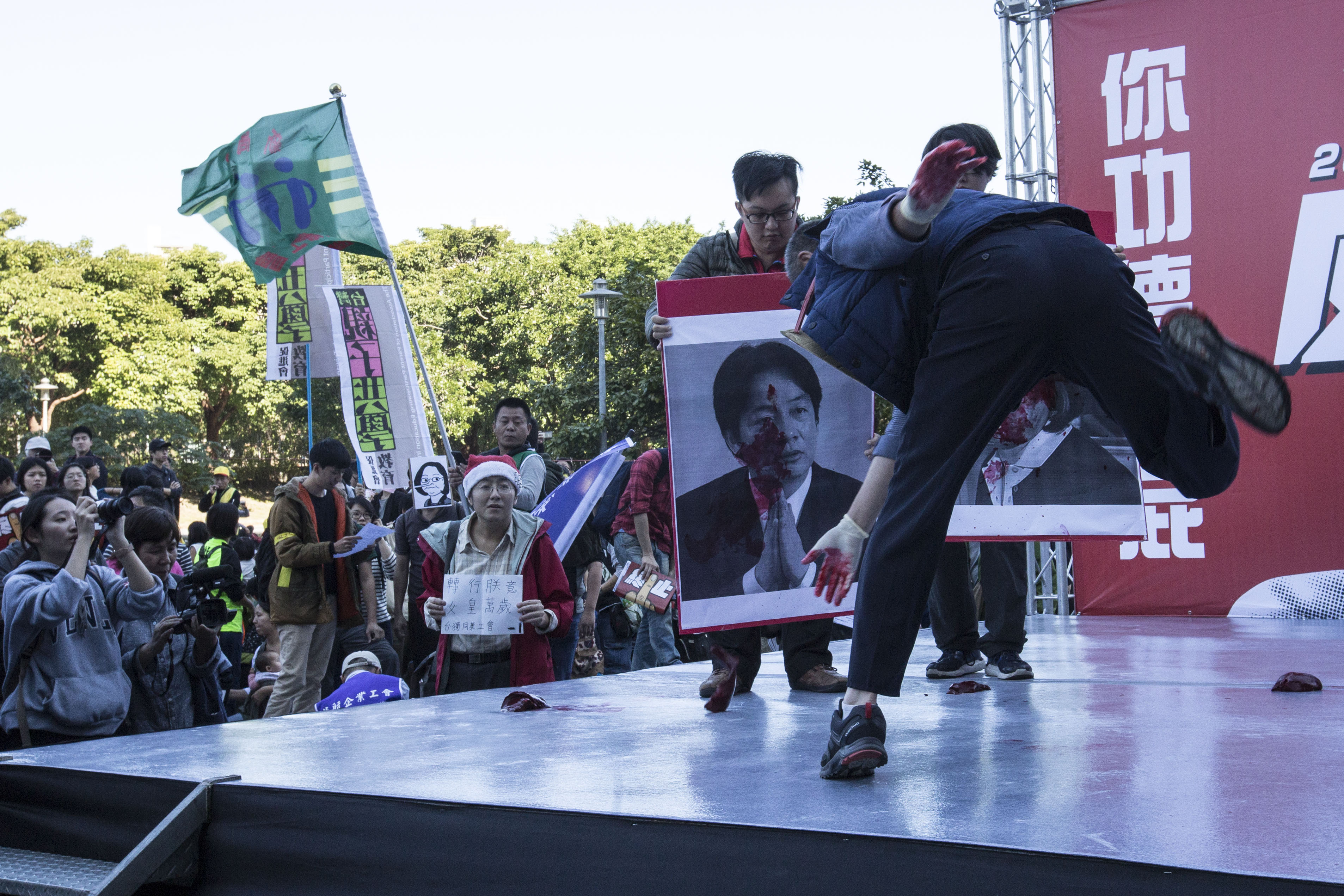 勞團發起萬人反對勞基法修惡遊行，勞工代表把象徵過勞的肝用力砸向行政院長賴清德的照片上。