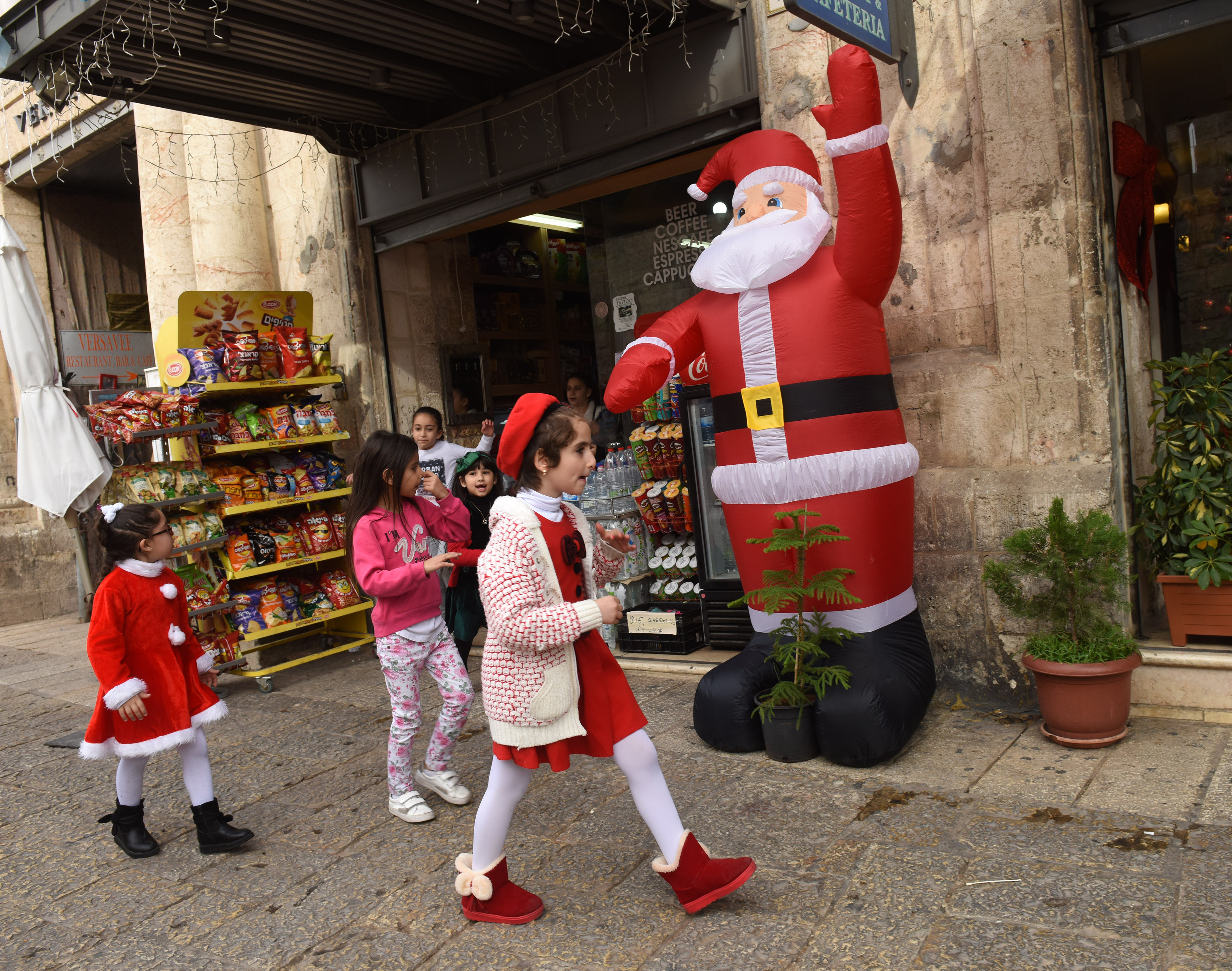2017年12月22日，巴勒斯坦小女孩走過耶路撒冷舊城區的耶誕老人充氣玩偶。當地商家表示，川普選不耶路撒冷為以色列首都讓當地耶誕節的觀光業幾乎停擺。（東方IC）