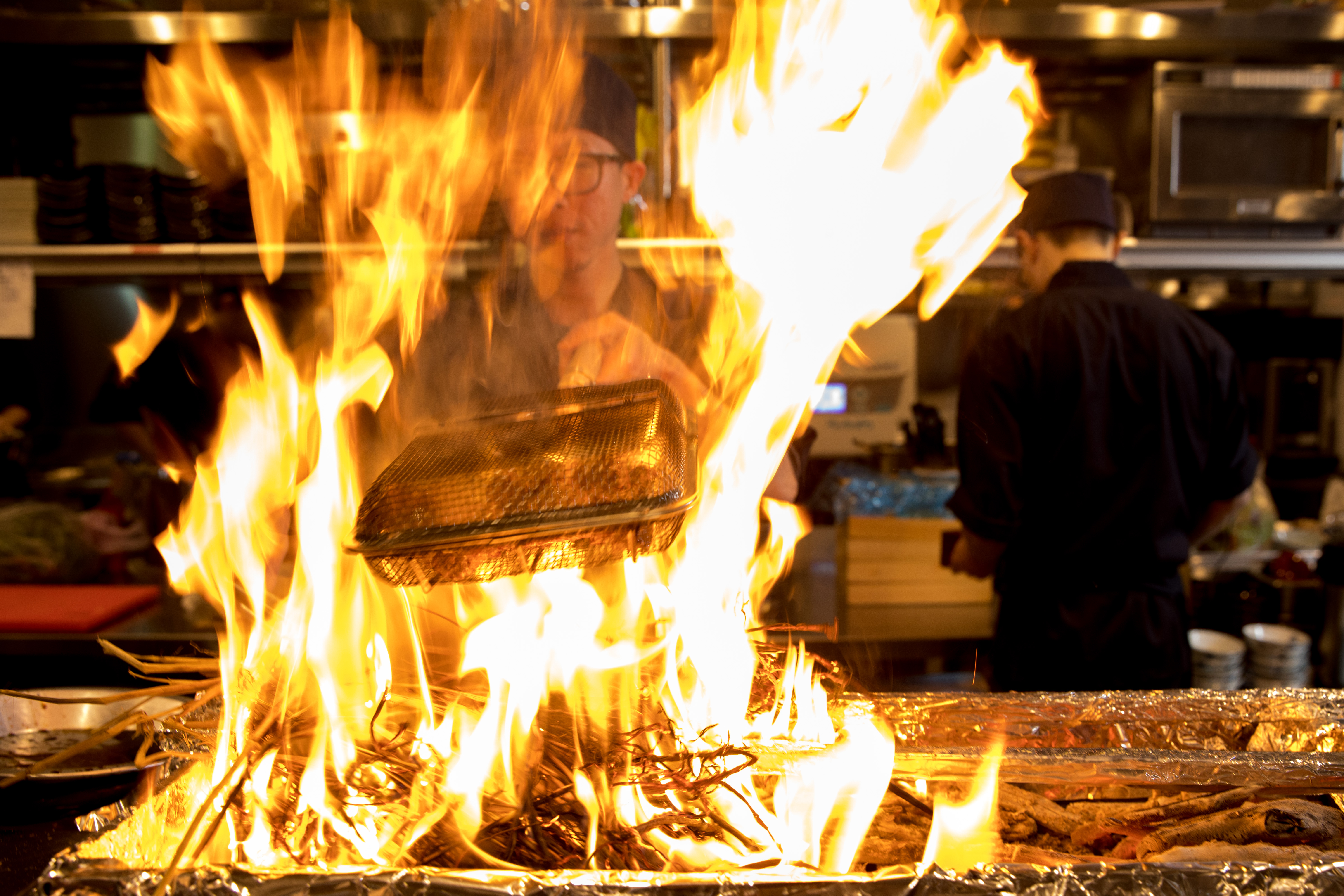 點燃稻草燻香食材時，火焰竄爬，聲色俱足。
