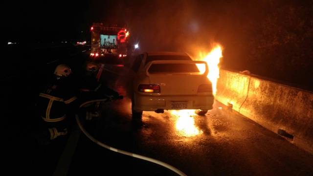 消防人車抵達時，轎車底盤竄出火舌，沒多久車子變成廢鐵。（消防局提供）