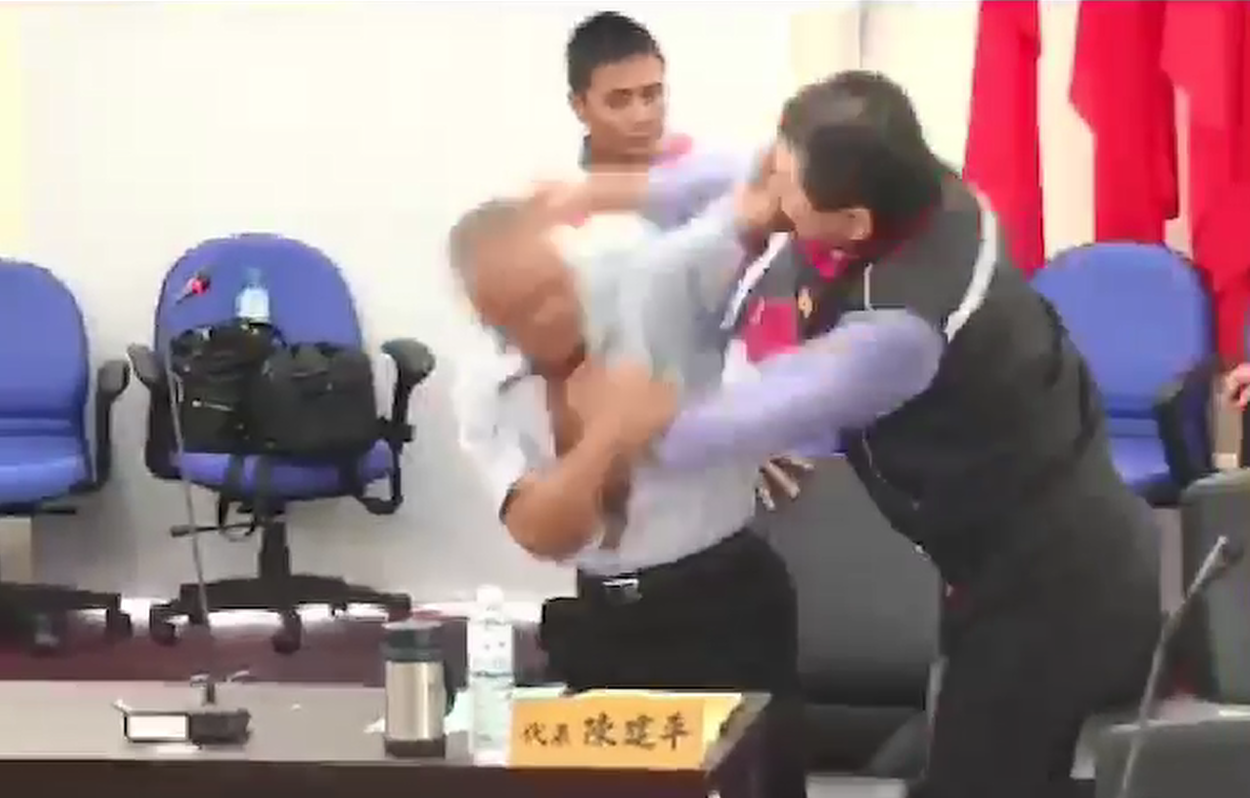綠島鄉代表會爆發全武行，鄉代陳建平（藍襯衫）與鄉長鄭文仁（黑背心）雙方近身擊臉。