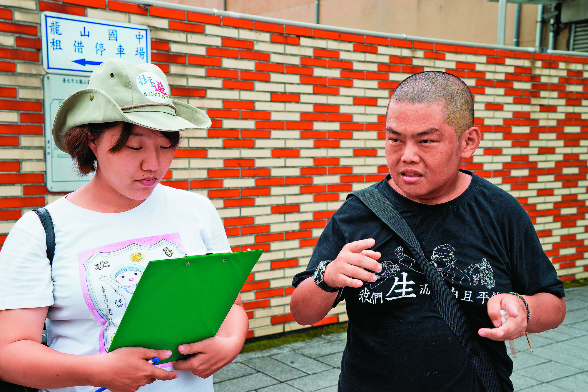 社工李佳庭(左)的工作是培訓遊民成為街遊導覽員。右為導覽員小胖,去年10月因心肌梗塞過世。(李佳庭提供)