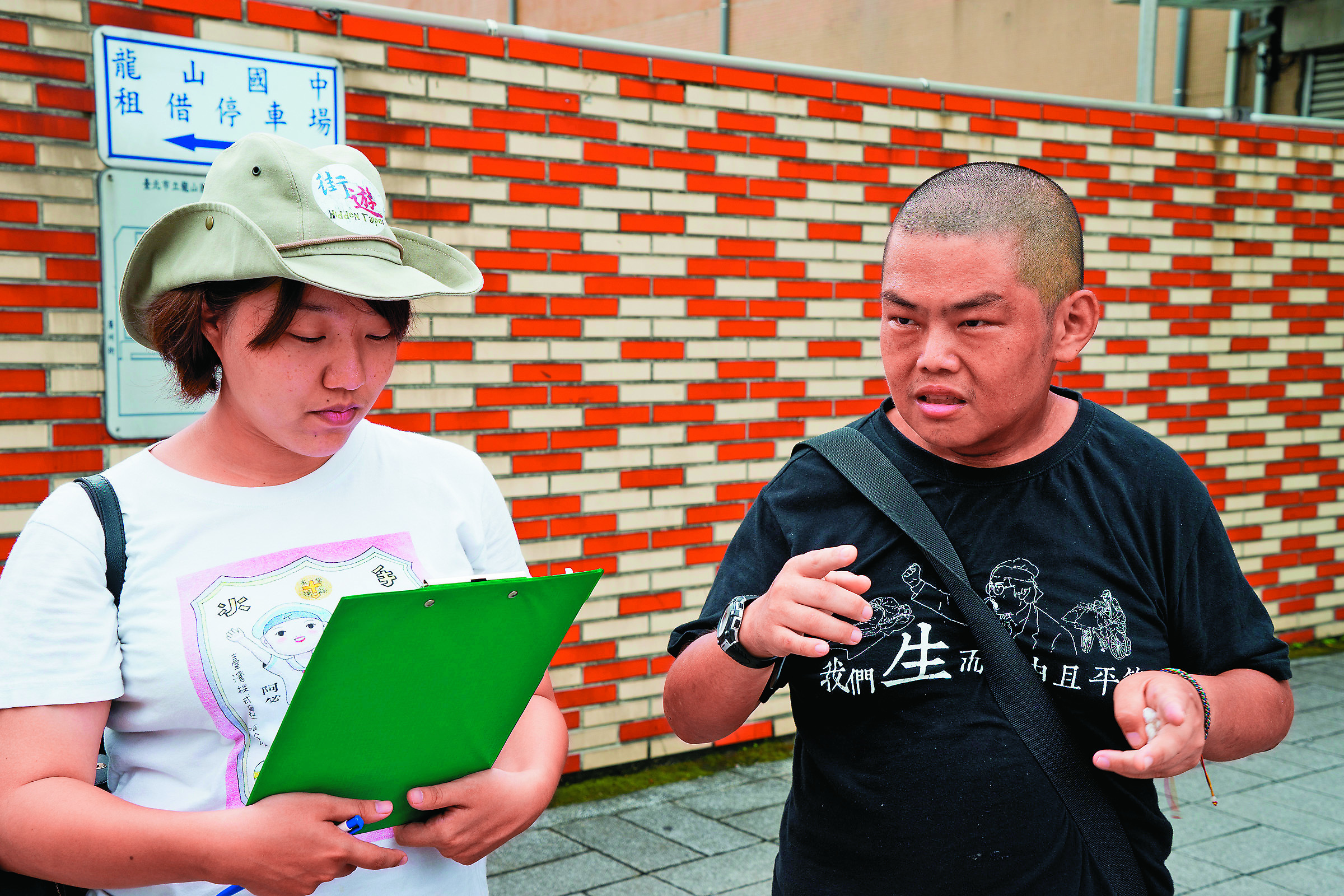 社工李佳庭（左）的工作是培訓遊民成為街遊導覽員。右為導覽員小胖，去年10月因心肌梗塞過世。（李佳庭提供）