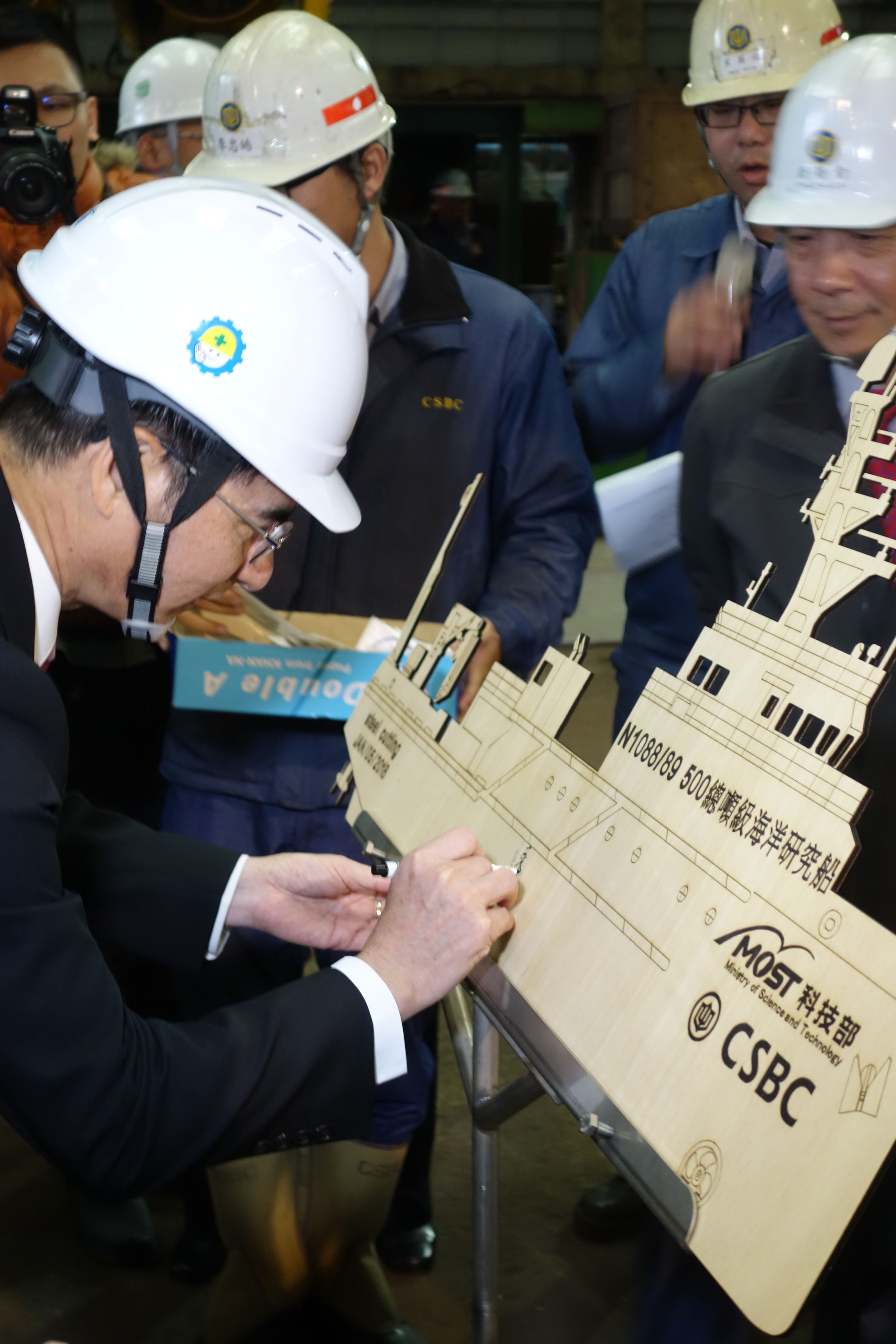 科技部長陳良基參加海研船開工典禮後，在紀念模型上簽名紀念。