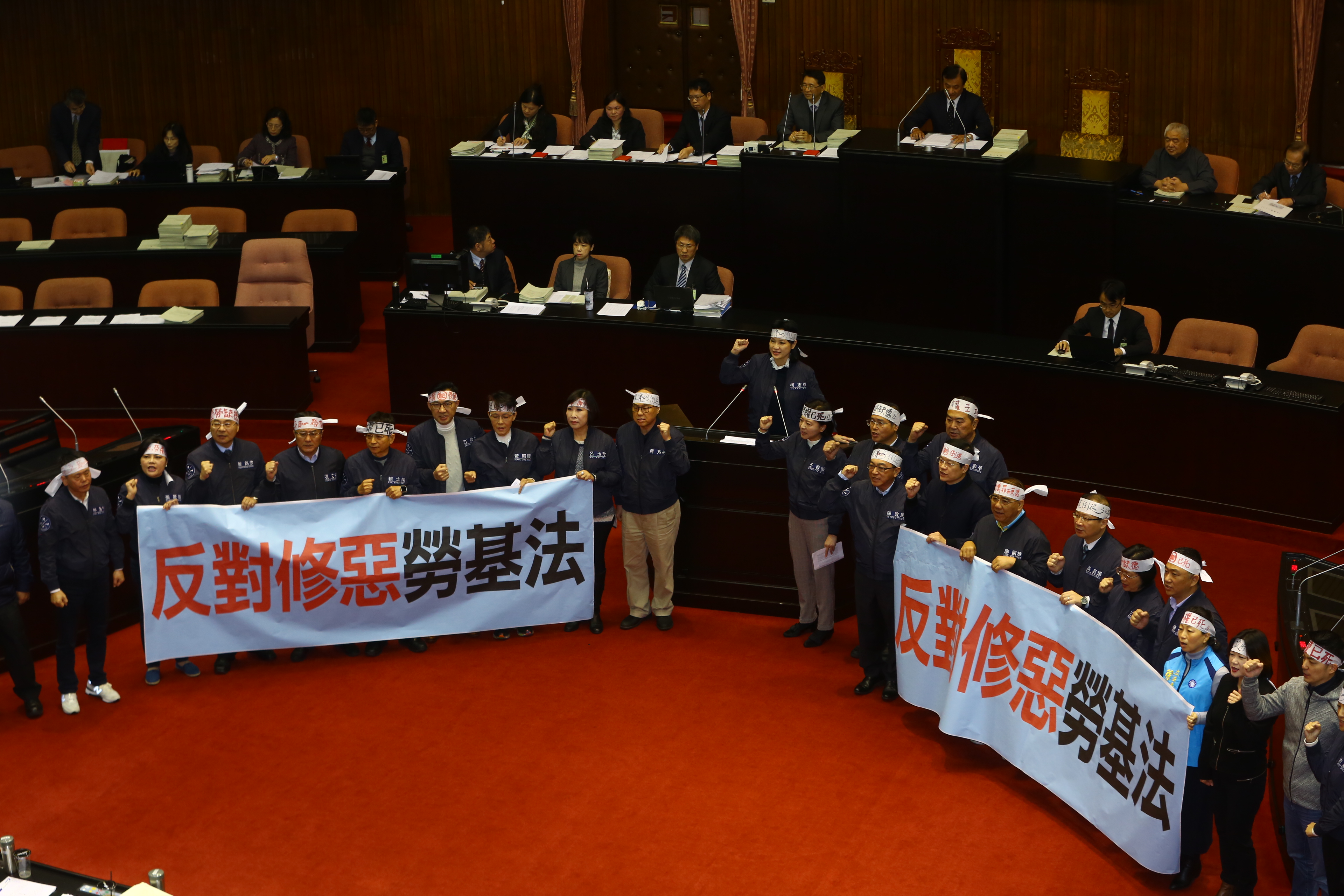 朝野協商無共識後，國民黨立委頭綁頭巾、拉起「反對修惡勞基法」布條，在議場發言台前抗議。