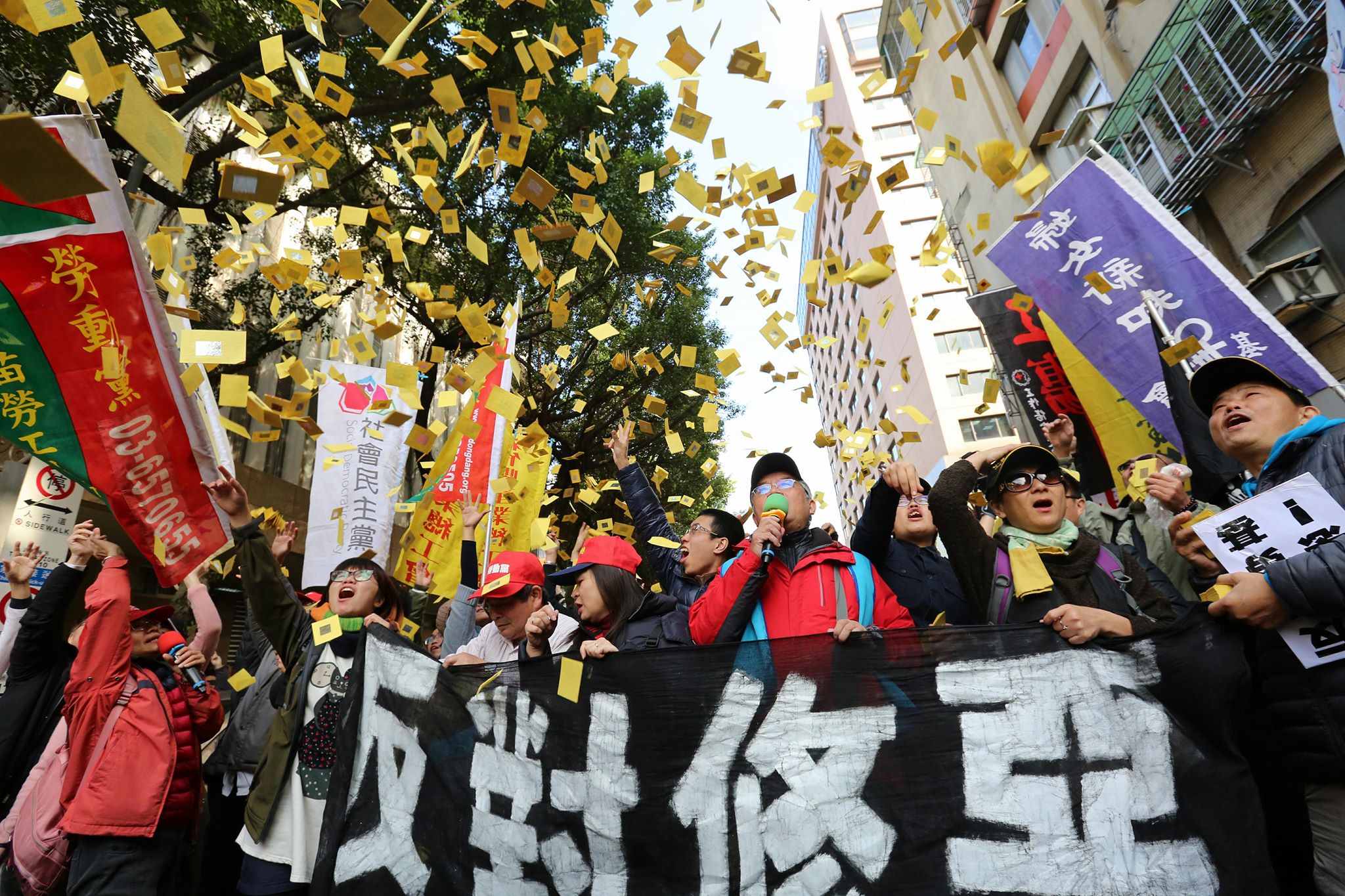 立院今早三讀《勞基法》，場外抗爭的勞團灑冥紙抗議。