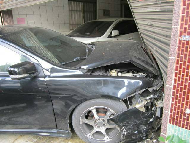 黑色轎車車頭毀損且民宅鐵門變形，可見衝擊力道之大。（警方提供）