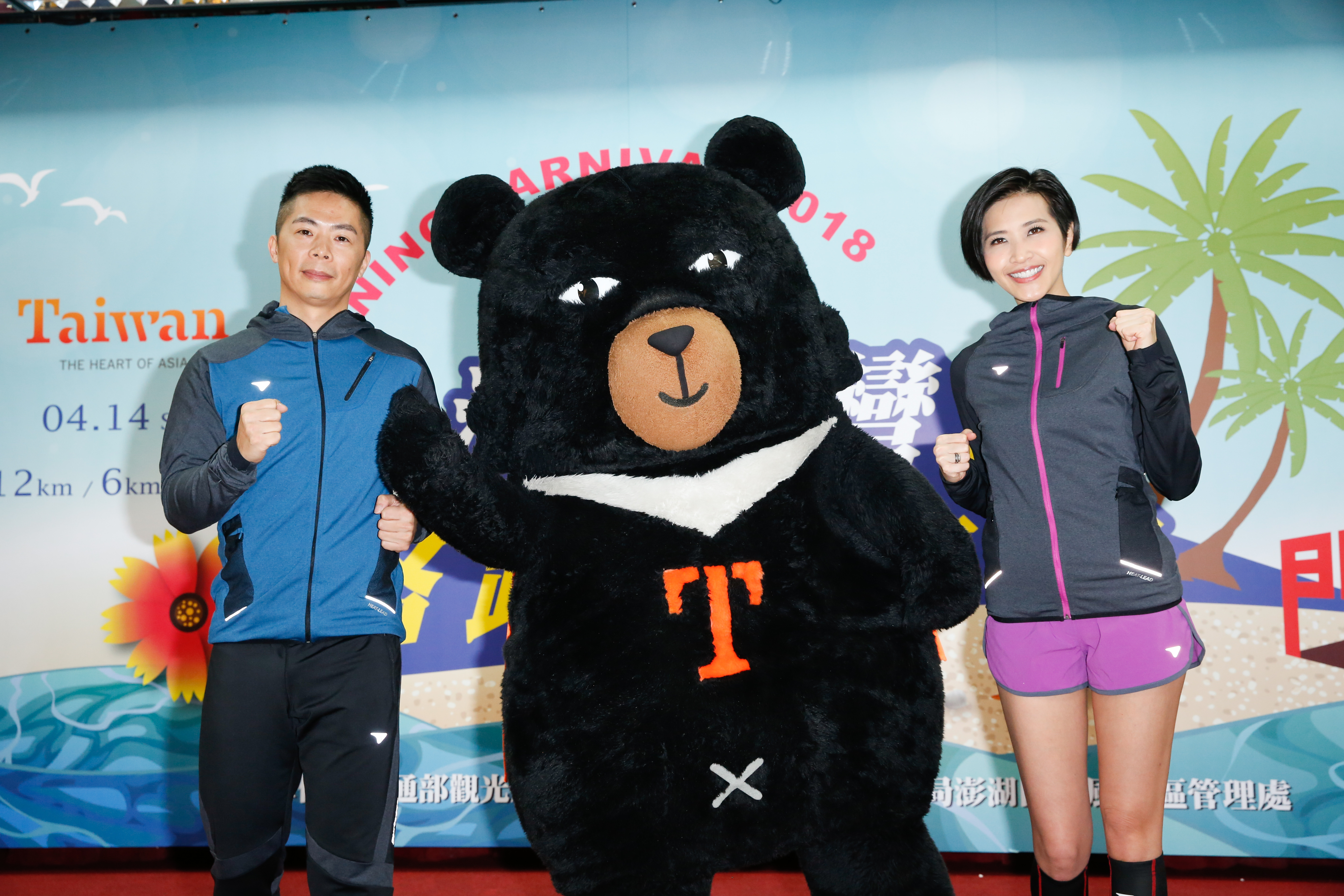 林義傑與梁一貞現身2018澎湖灣沙灘路跑嘉年華記者會，跟吉祥物喔熊相見歡。