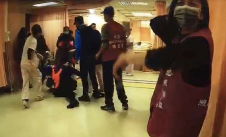 黃嫌打趴岳父，消防人員上前攔阻。（消防局提供）