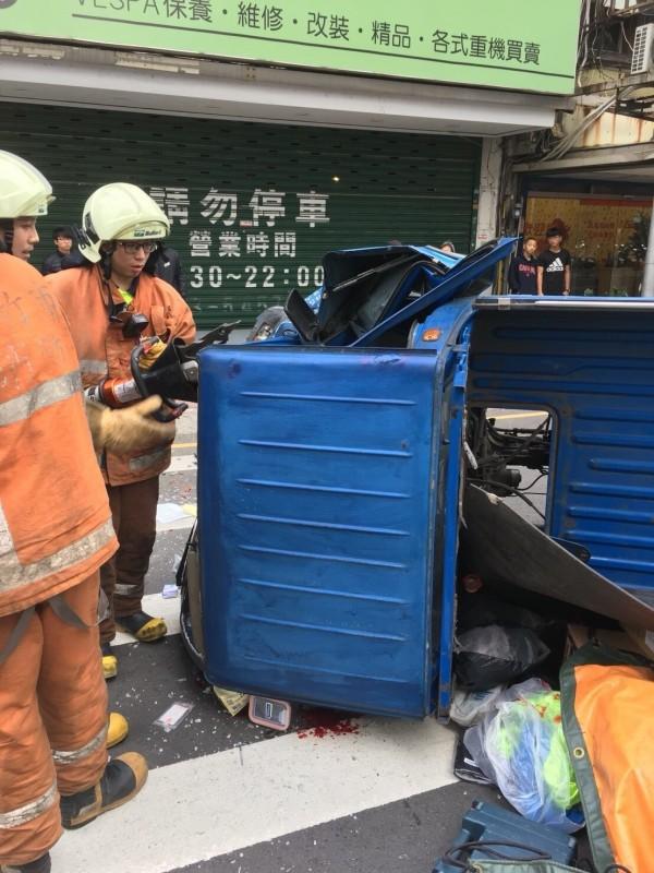 司機受困在受到撞擊後變形、扭曲的車體內，動彈不得。(消防局提供)