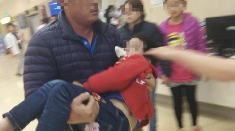 心急如焚的父親，在警方護送下抱著兒子衝向急診室。（警方提供）