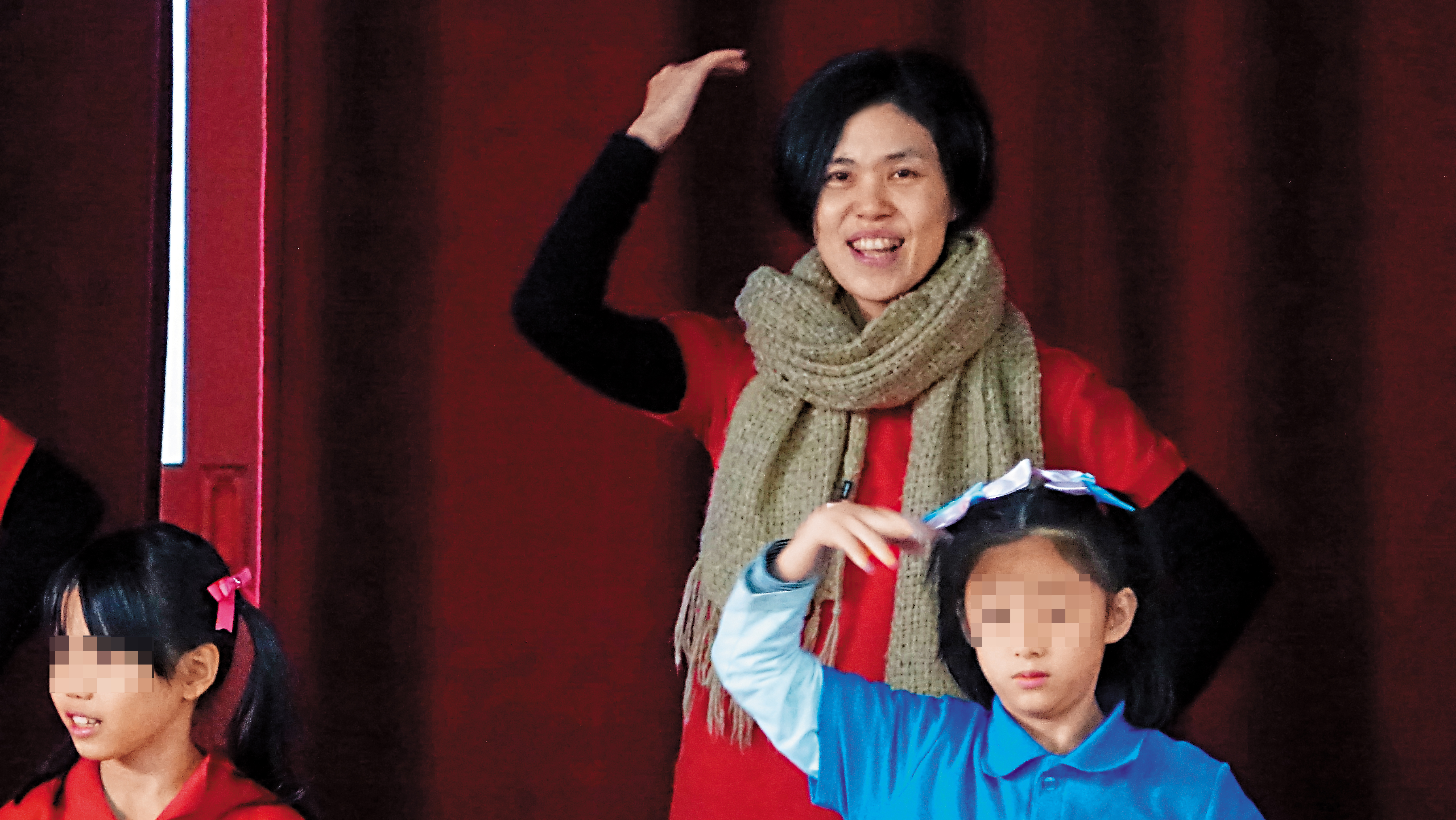 施宣榕強顏歡笑與管樂團家長們在舞台上跳舞。