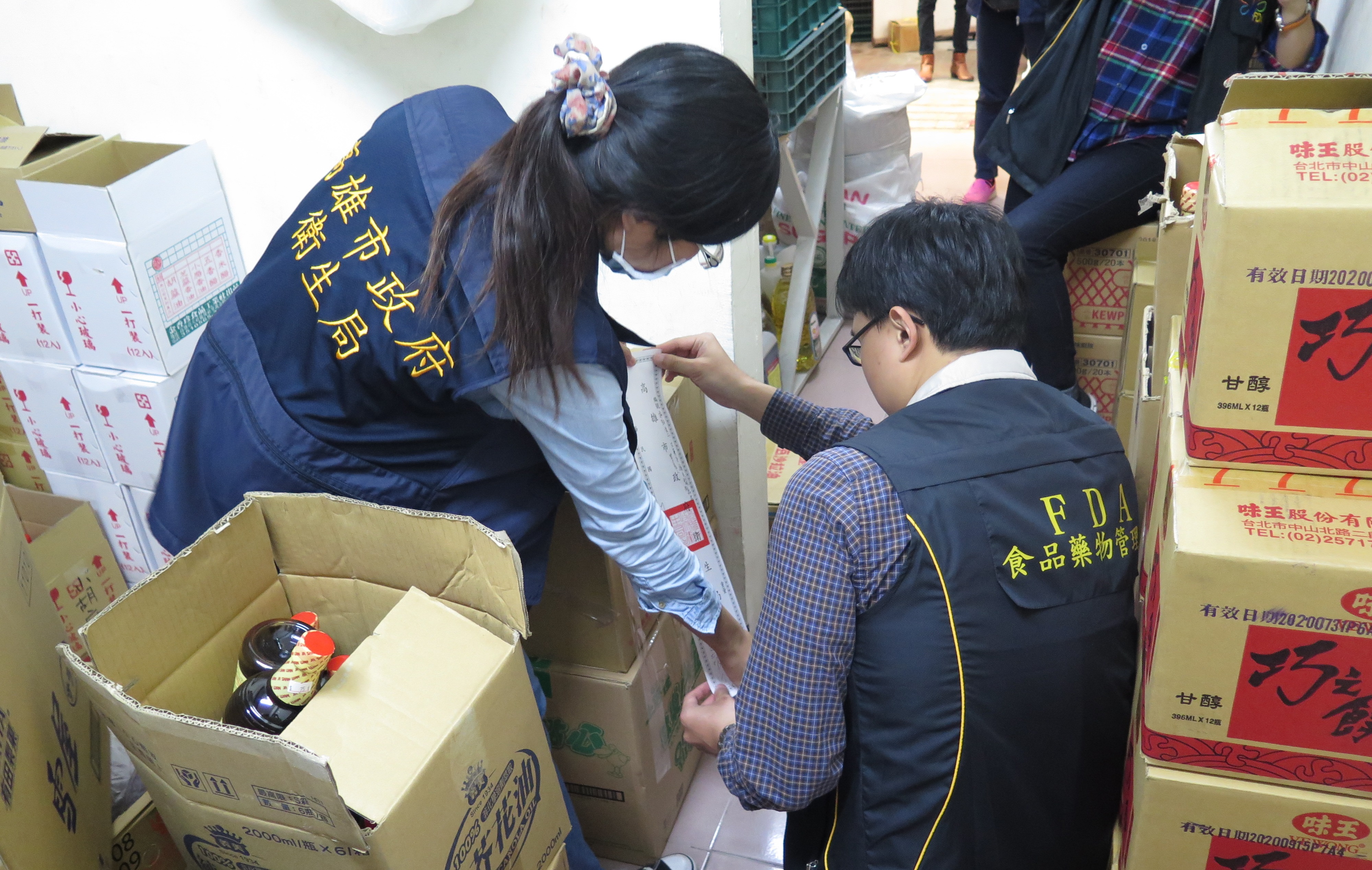 衛生局與檢警合作查獲年豐食品行涉嫌販售及改標逾期食品，門市倉庫逾期品遭查封稽查。（高市衛生局提供）