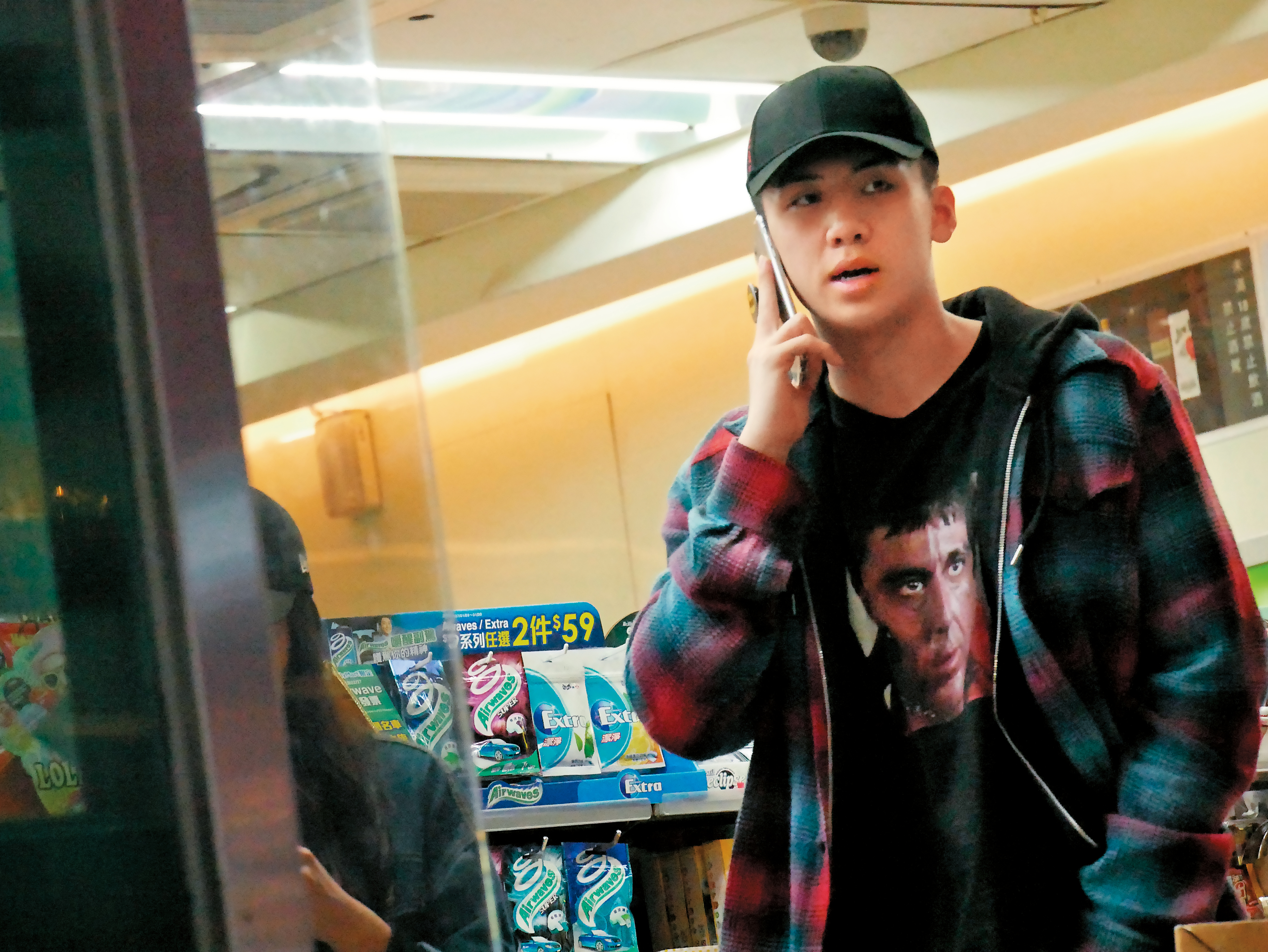 寶弟在超商裡一直忙著講電話，女伴在旁滑手機。