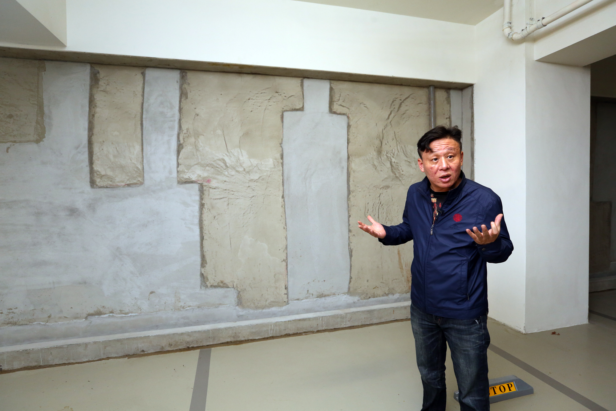 曲先生花7,000萬買下頤湖苑頂樓戶，卻為了地下室漏水問題與國泰建設協商未果，讓他氣了半年之久。（註：此為拆掉複壁後的牆面，近黃色為舊牆，其他是漏水修補處。）