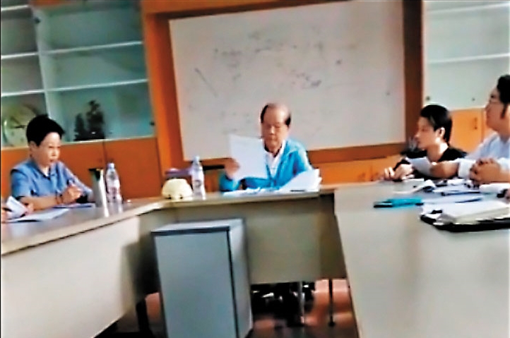 深圳大友鋼鐵的會議上，已改名換姓為「付祝」的羅福助，不發一語地接過文件審慎批閱。（讀者提供）