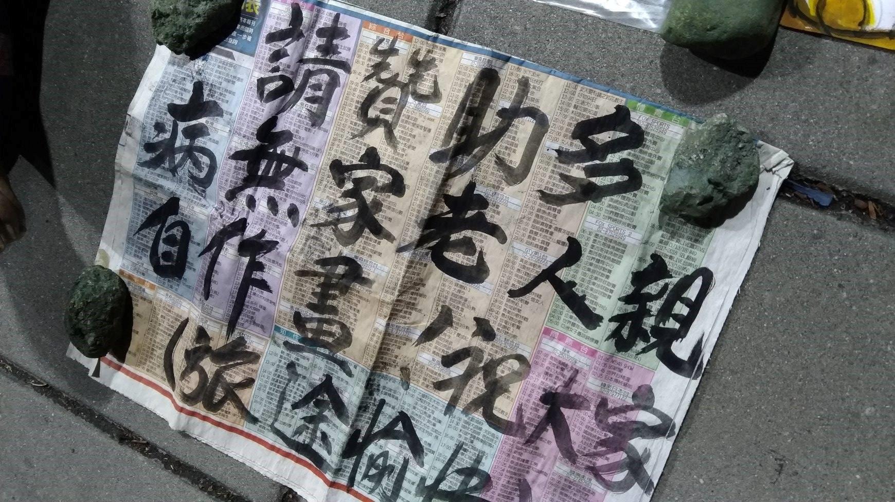 街友阿伯用報紙寫的賣藝看板。(時代力量三民區議員參選人林于凱提供)