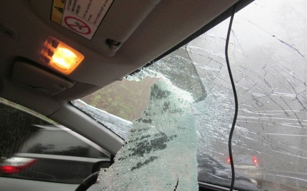 石頭砸破車窗，掉入車裡，夫妻閃避不及，被砸中骨折。（消防局提供）