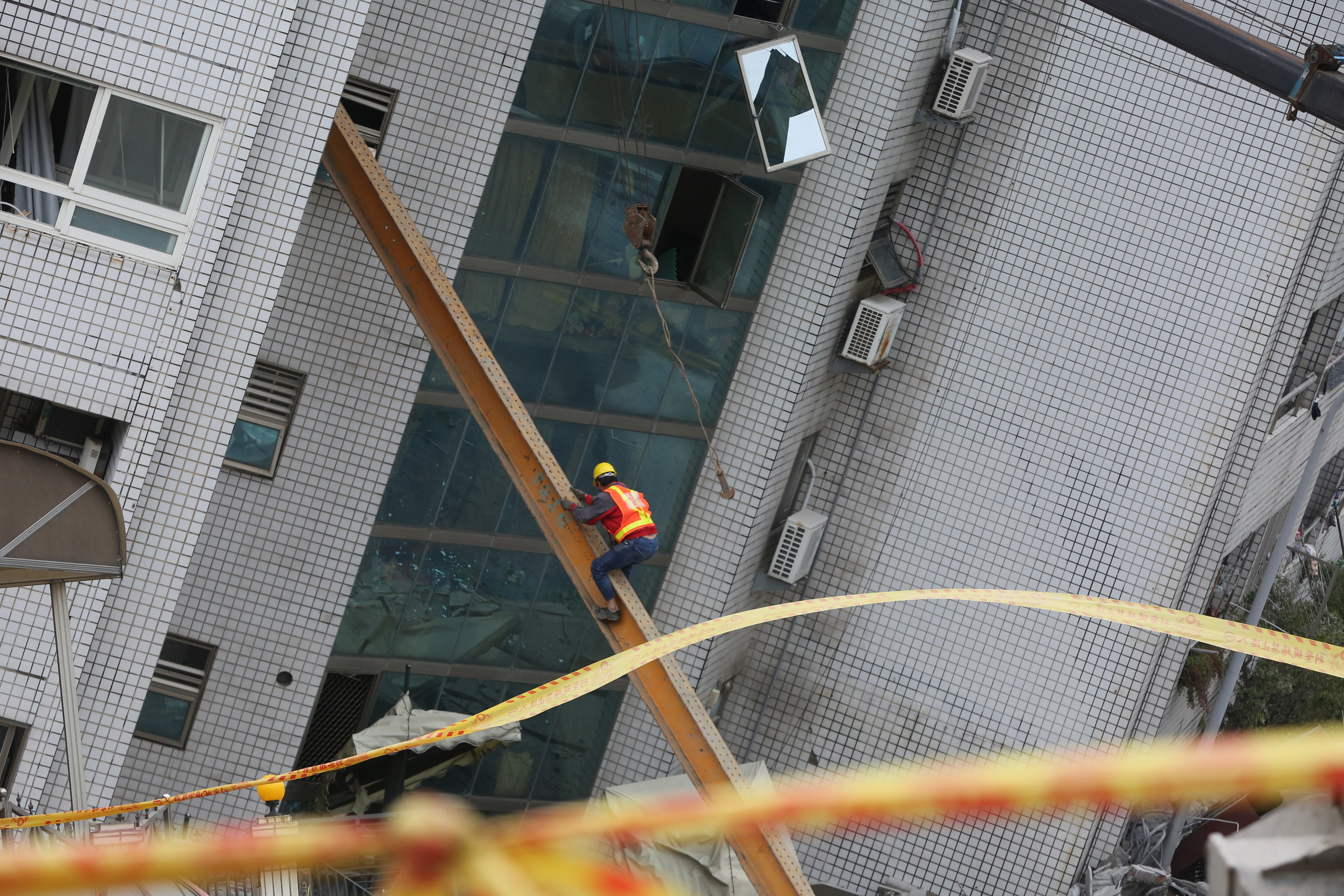搜救員靠著鋼梁，冒險進入雲翠大樓。