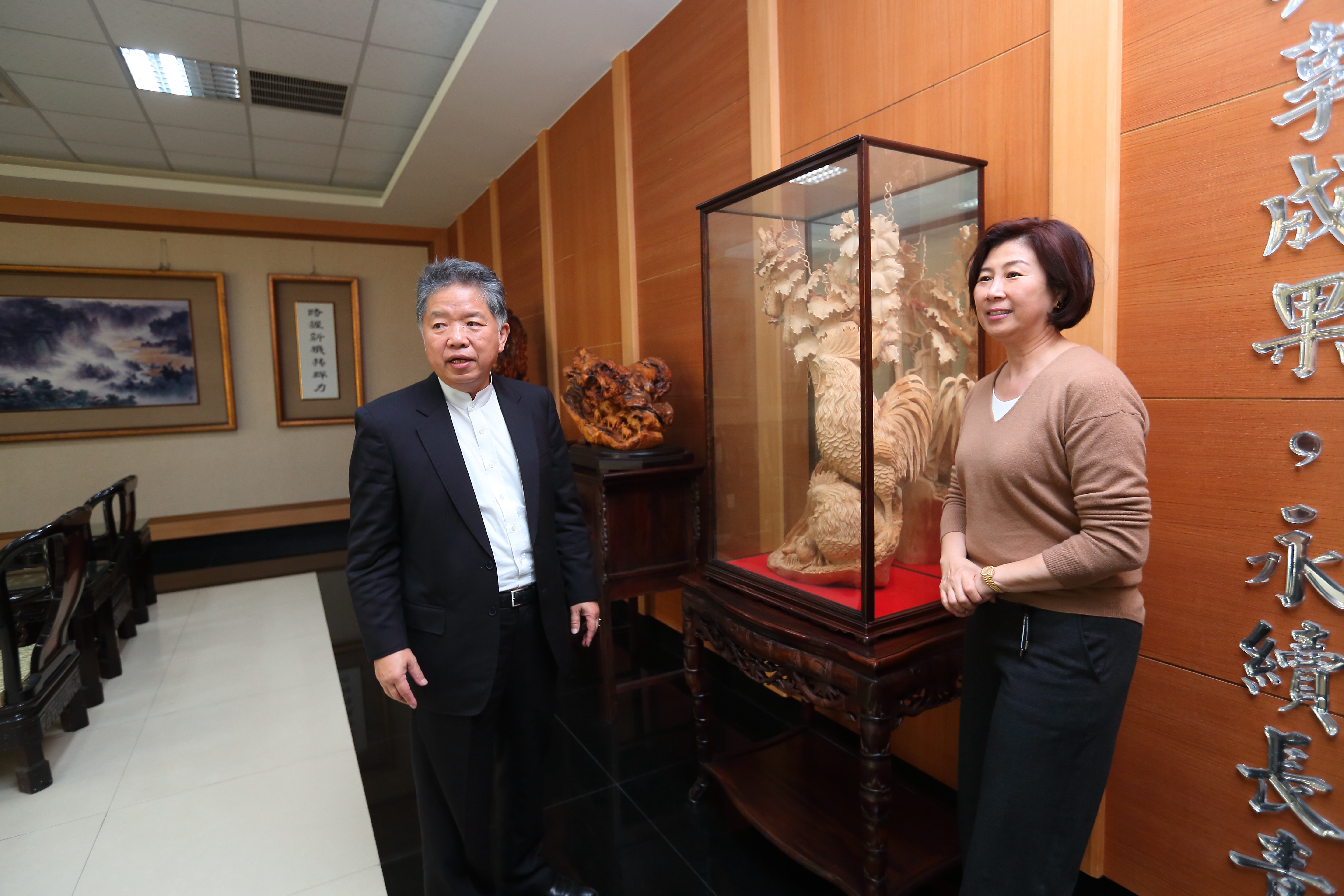 黃亞興（中）和老婆劉祖英（右）都喜歡大型木雕，認為木雕有深厚的文化底蘊。