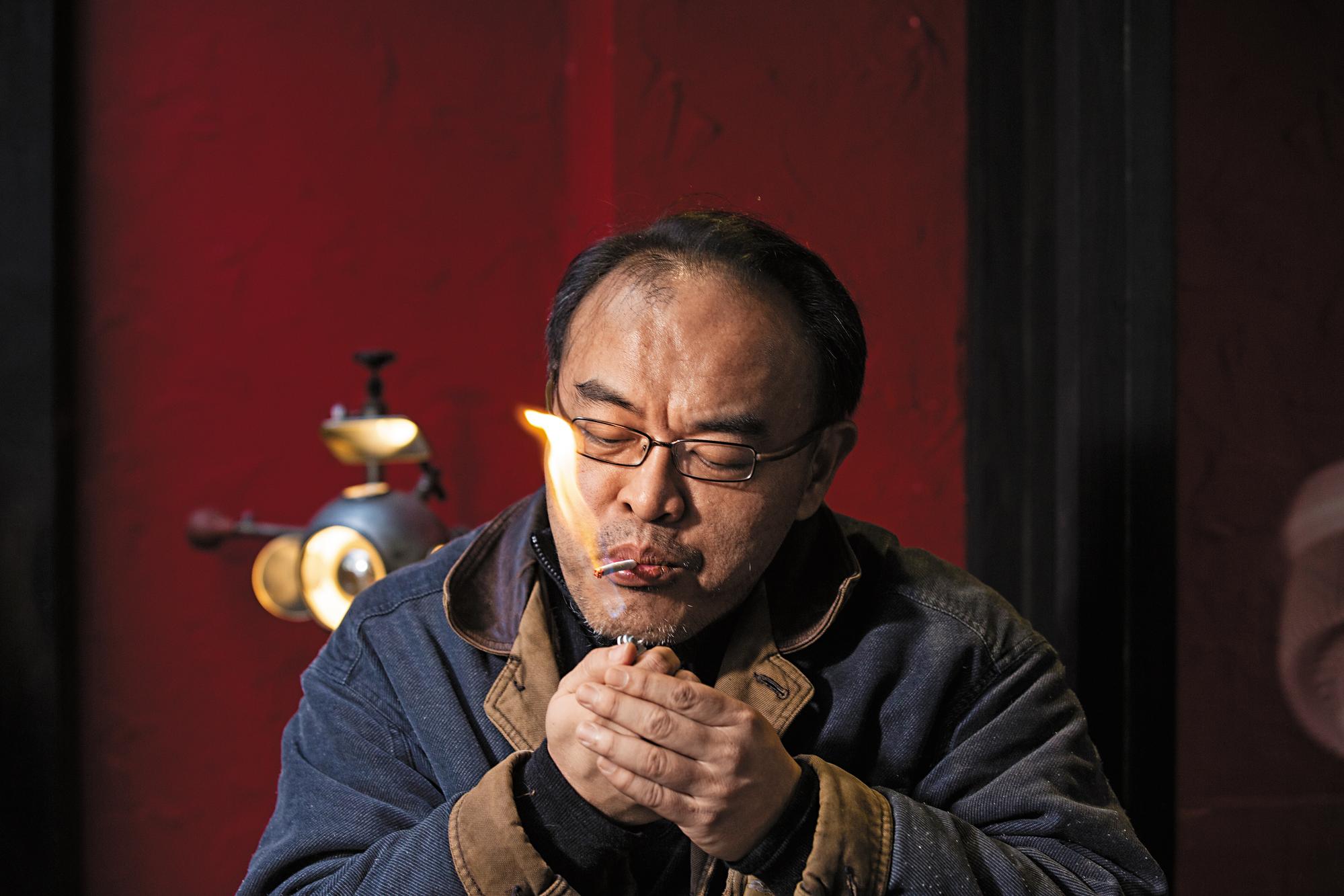 駱以軍總是坐在戶外咖啡座寫稿，也有專屬位置。他為了抽菸，就算寒流也不進室內。