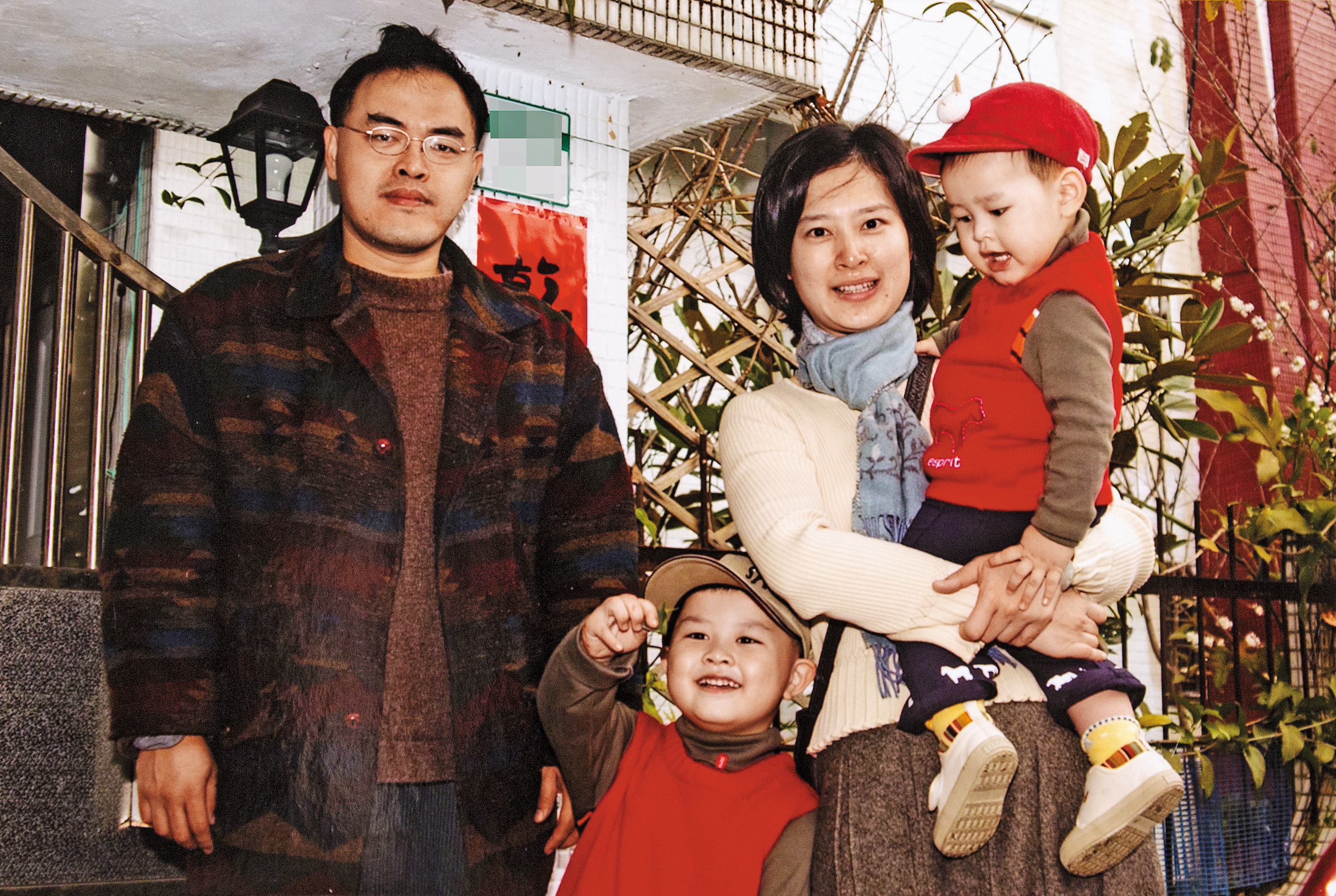 駱以軍和妻子鄭穎（右2）生了2個兒子，當時住在深坑，幫孩子穿紅衣紅帽，準備去拜年。（駱以軍提供）