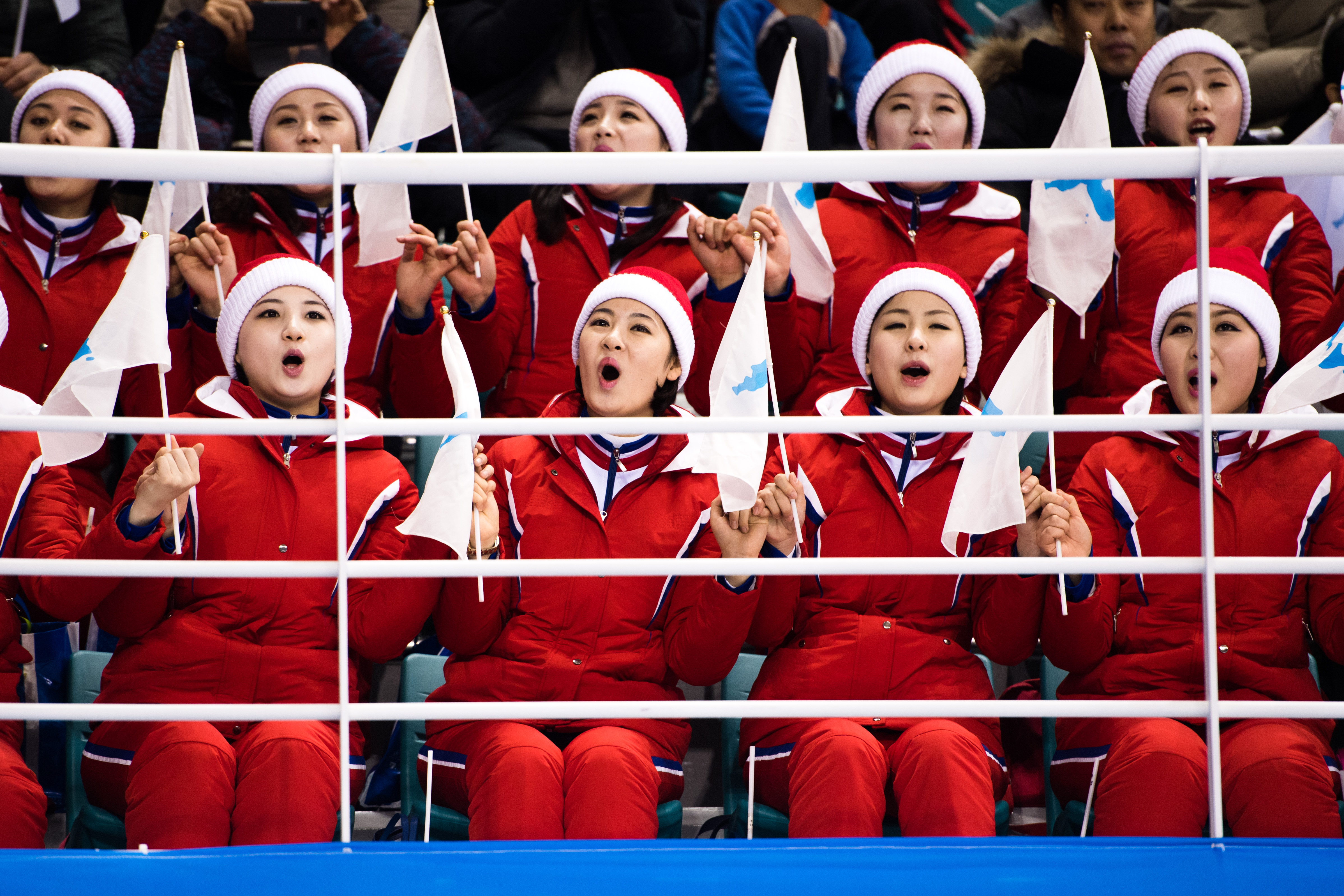2018年2月10日，南韓平昌。北韓啦啦隊在女子冰球賽中手持「半島旗」為南北韓聯合隊加油。（東方IC）