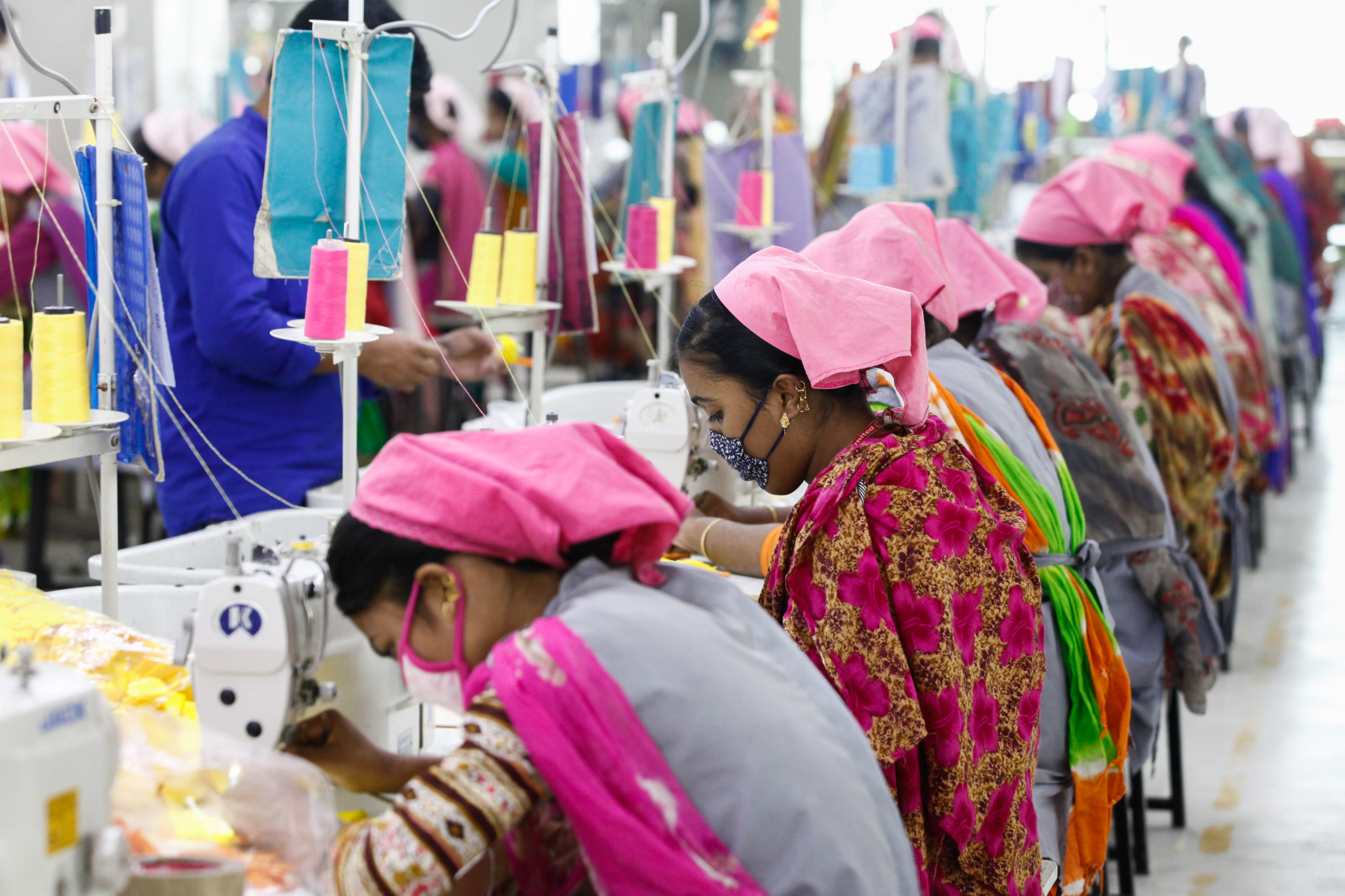 成排女工在縫紉機前埋首工作,是南亞和東南亞成衣工廠內常見的景象。(東方IC)