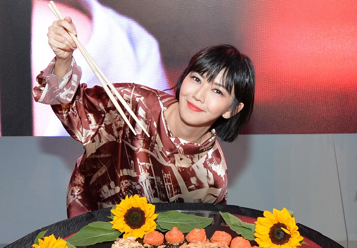 孫燕姿在首印會上拿起特長的筷子「撈魚生」，祈求來年步步高升。（大馬環球音樂提供）