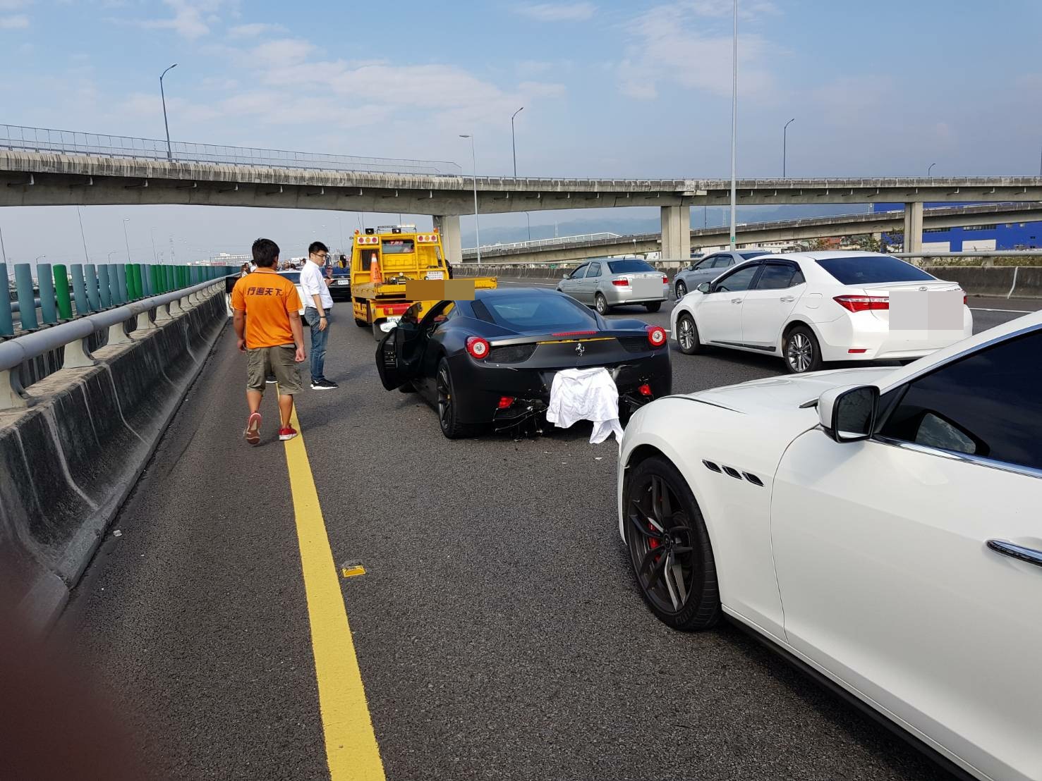 法拉利跑車也受到波及，車尾蓋著白布之處也有些微受損。（台灣新聞記者聯盟資訊平台）