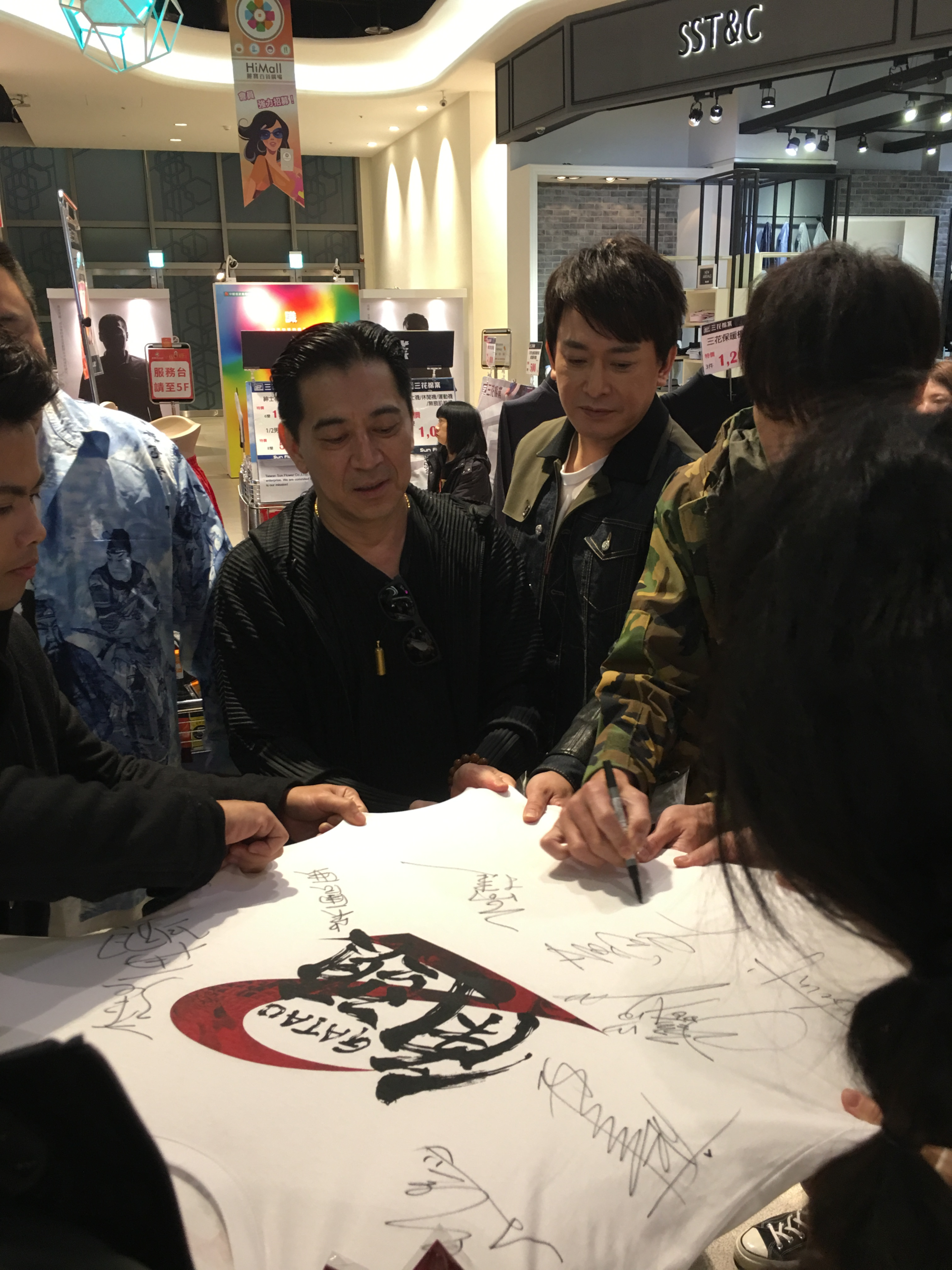 粉絲拿抽中的角頭T恤給主角群簽名。（齊石提供）