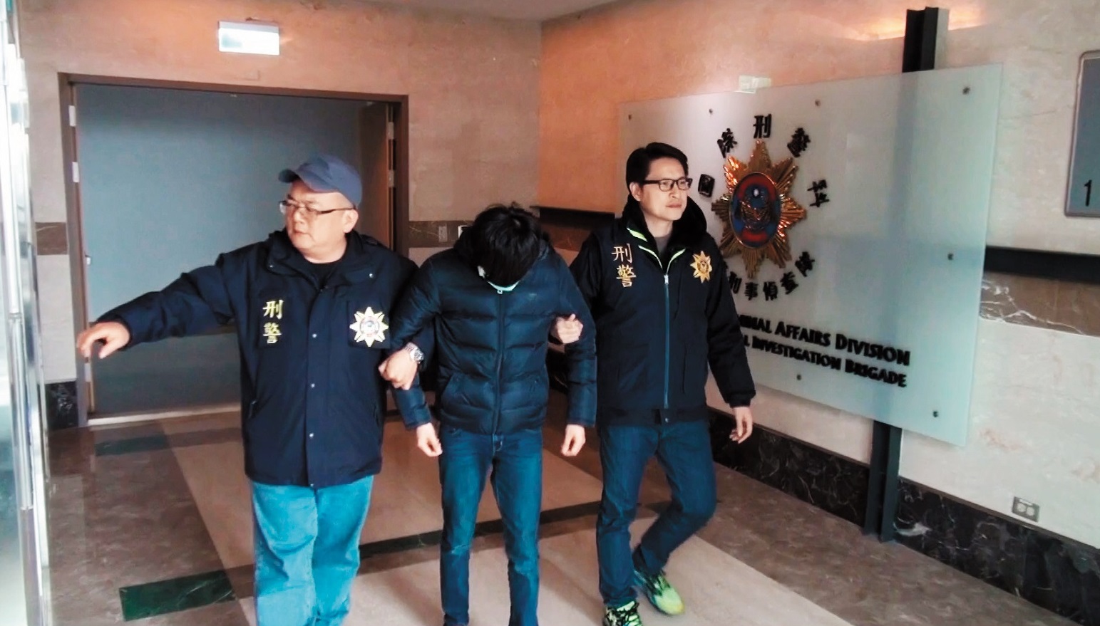 始終低頭的溫姓嫌犯，大量下載散播兒少色情影片，成為世界百大惡狼第33名，讓台灣留下污名。（警方提供）