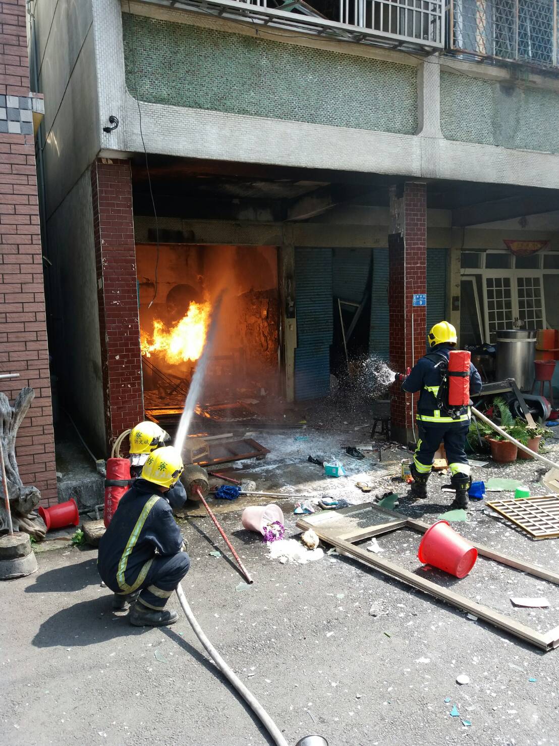 警消到場時民宅竄出火苗,物品散落一地可見爆炸威力之大。(屏東警消提供)
