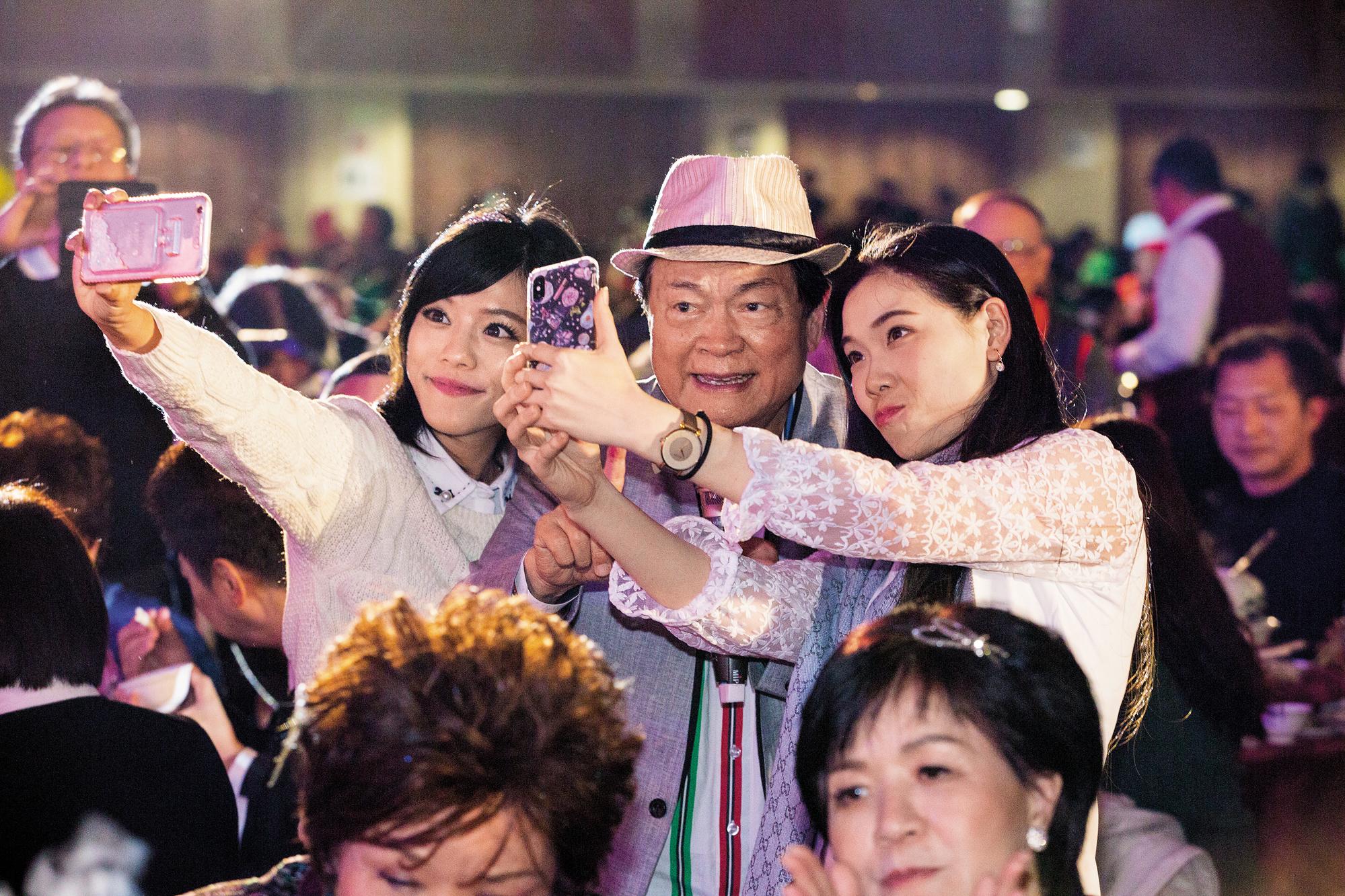 〈安童哥買菜〉成全了劉福助(中)的演藝生命,這天照例唱了,從台上唱到台下,和觀眾握手、合照,歌詞一句沒漏。