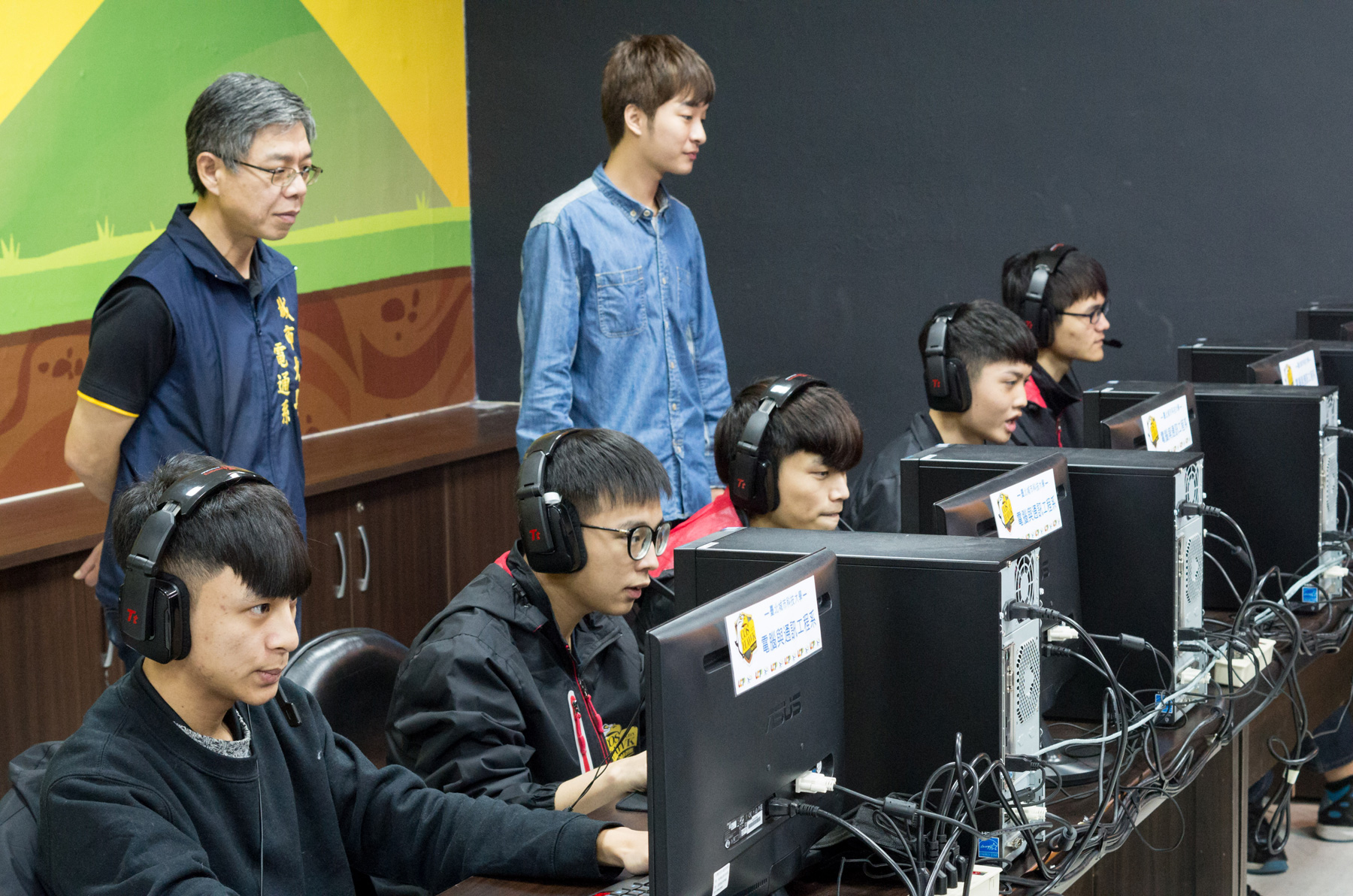 「城市蒼鷹」的《英雄聯盟》戰隊，五位選手由左至右為施韋丞（上路）、廖佳興（打野）、詹益炫（中路）、陳柏翰（AD）、洪勝郁（輔助），站立者左為電通系主任詹勳鴻，右為教練周奕傑。