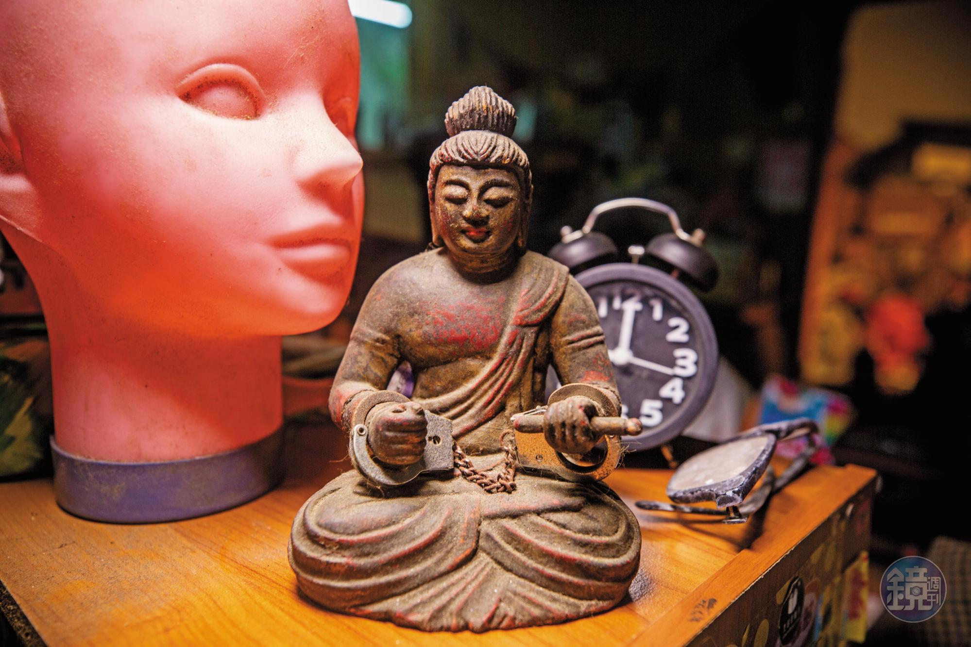 麻利的收藏品各式各樣,幾乎沒有什麼規則。圖中佛像上的手銬,是麻利自己裝上去的。