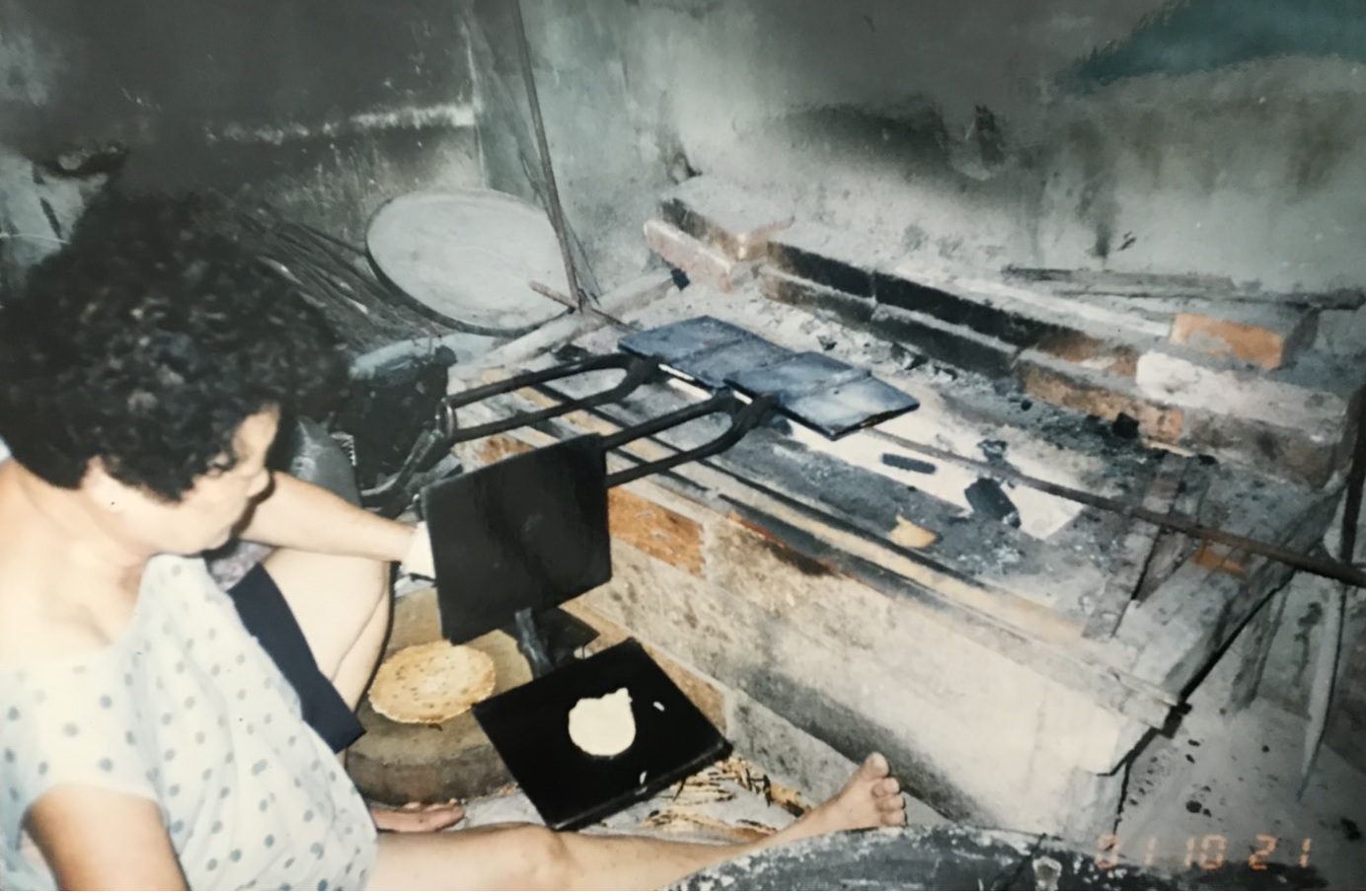 早年烤餅爐台低矮，第2代楊玉釵幾乎是席地而坐製餅。（獅伯百年手工煎餅提供）