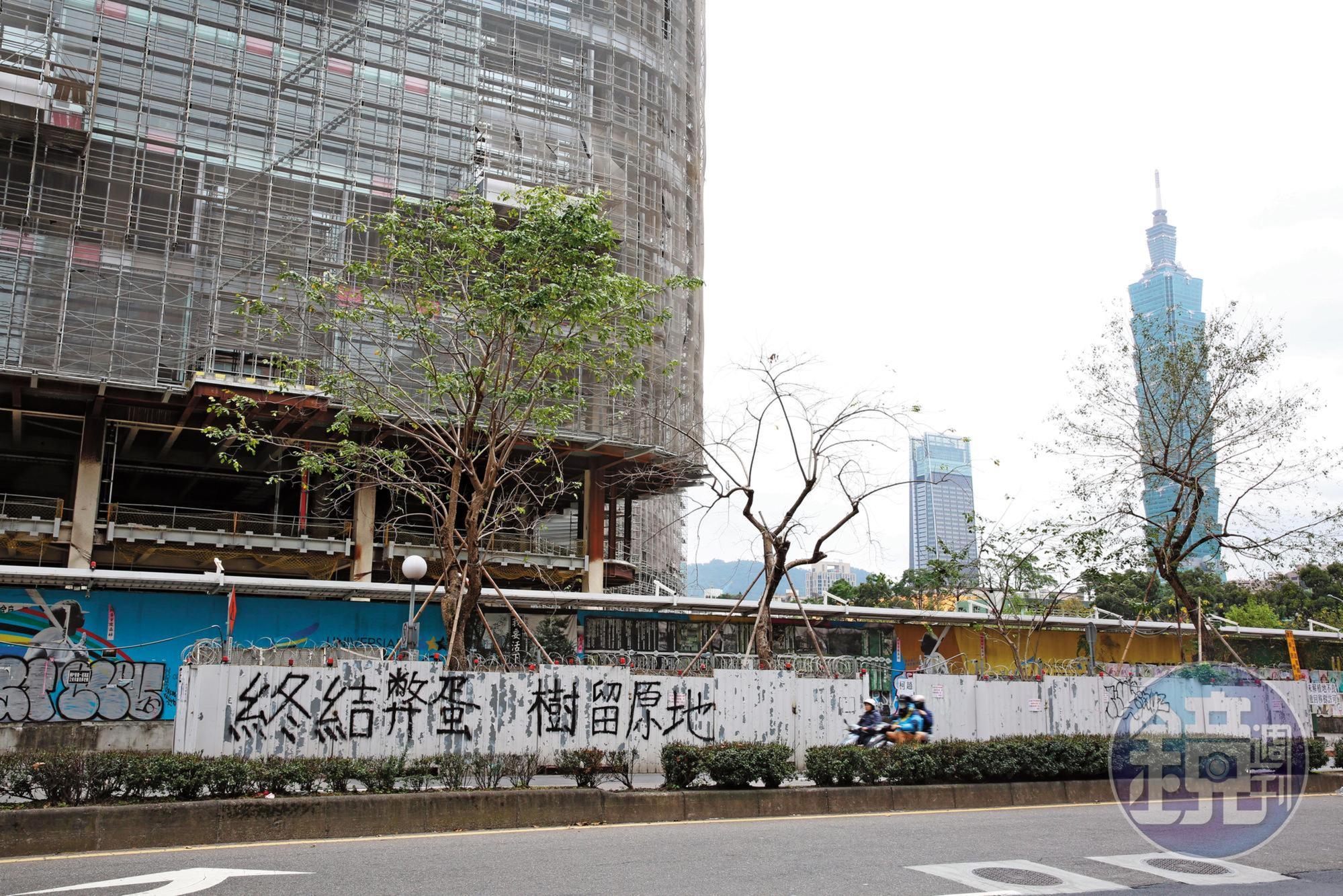 大巨蛋圍籬外牆遭反巨蛋的護樹團體懸掛布條抗議,柯團隊也擔心,讓大巨蛋復工超車,恐不利選情。