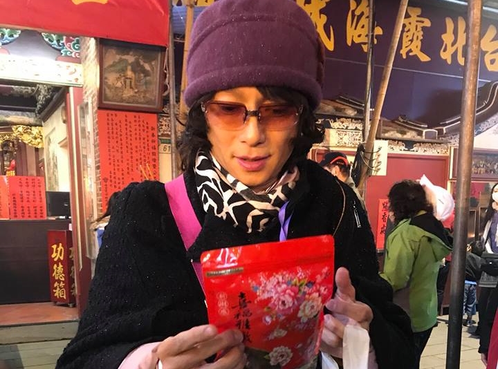 謝祖武女裝扮相進入廟中合十參拜，輕易騙過拿香參拜的人群。（謝祖武提供）