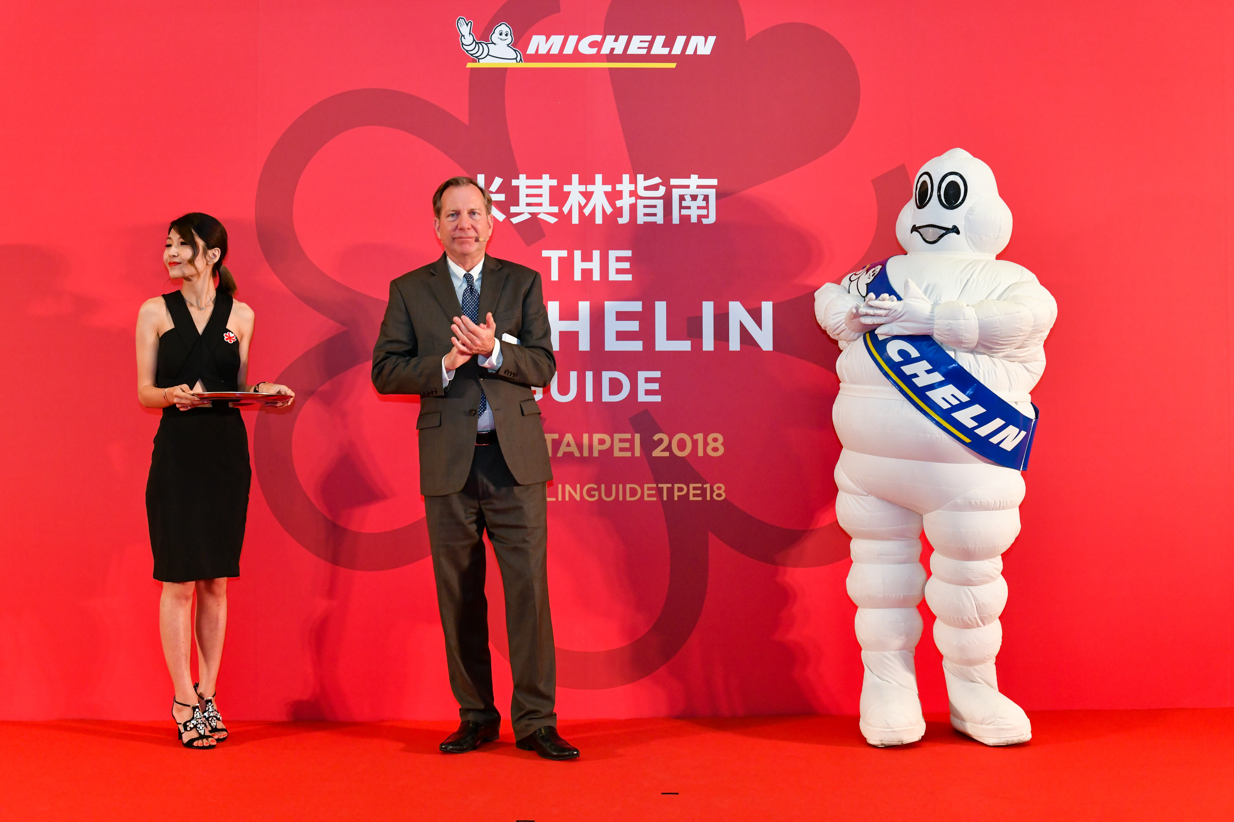 明福餐廳沒出席米其林頒獎典禮，只有米其林寶寶（右）與米其林指南國際總監Michael Ellis（中）尷尬拍手。
