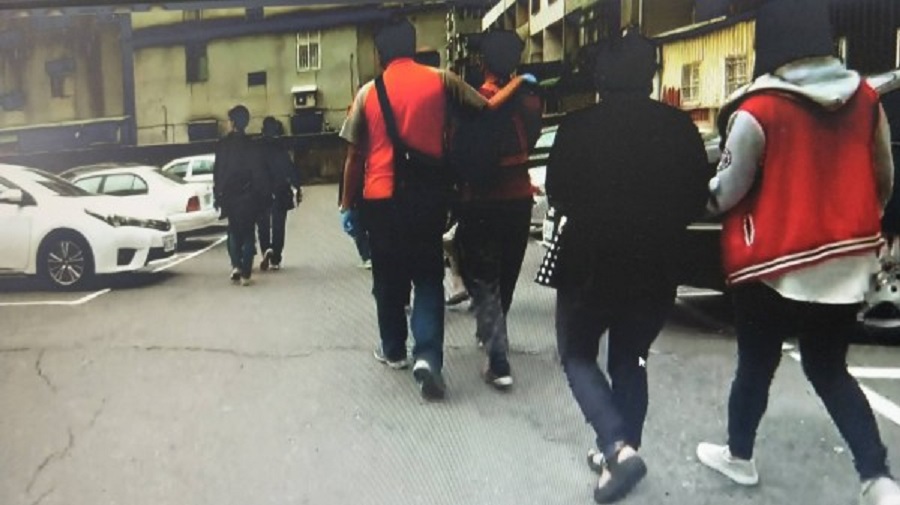 警方在賓館的停車場押解落網的毒蟲們準備帶回分局訊問。（警方提供）