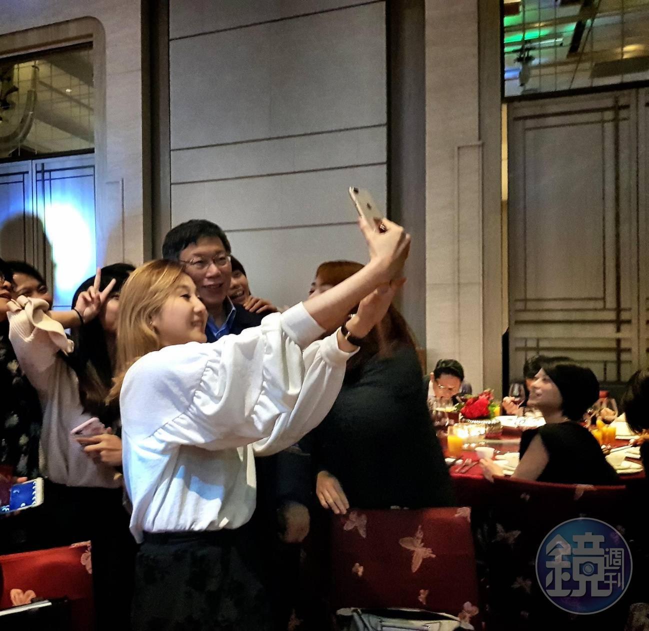 台北市長柯文哲人氣不減,15日參加中華民國不動產代銷全聯會理事長交接時,被女記者們簇擁玩自拍。