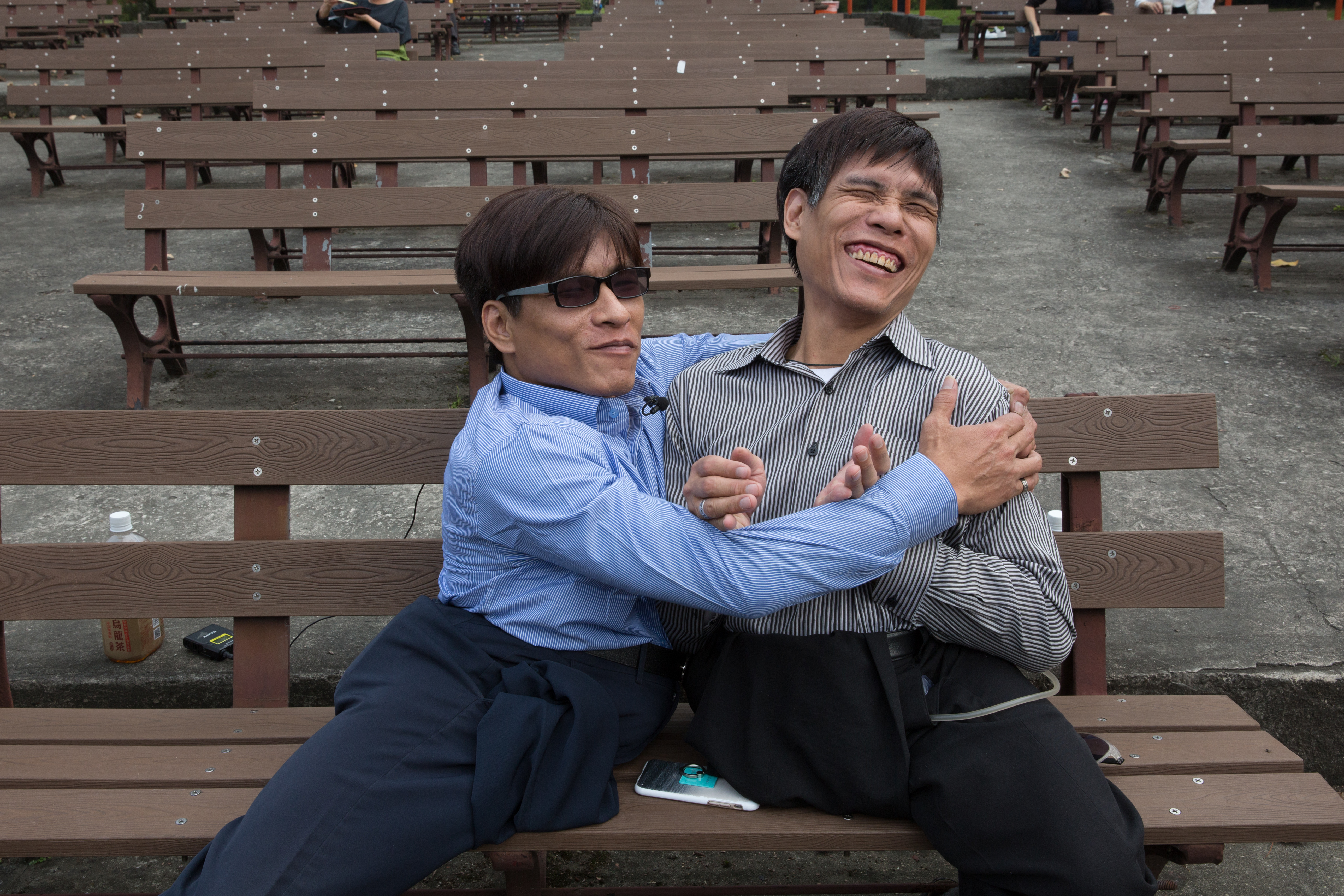 兩兄弟抱在一起，笑著談童年往事，彼時常穿過二二八公園，到台大醫院看診，或是到附近逛街。