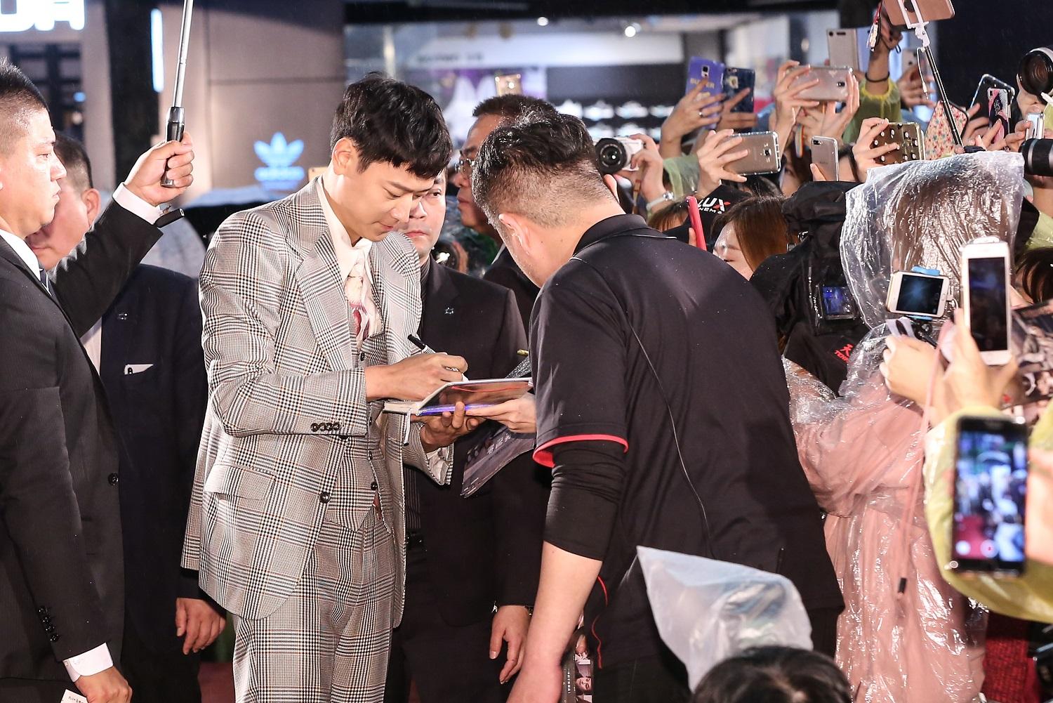 姜棟元在《宅配男逃亡曲》首映會紅毯上，與粉絲握手、簽名展現親和力。