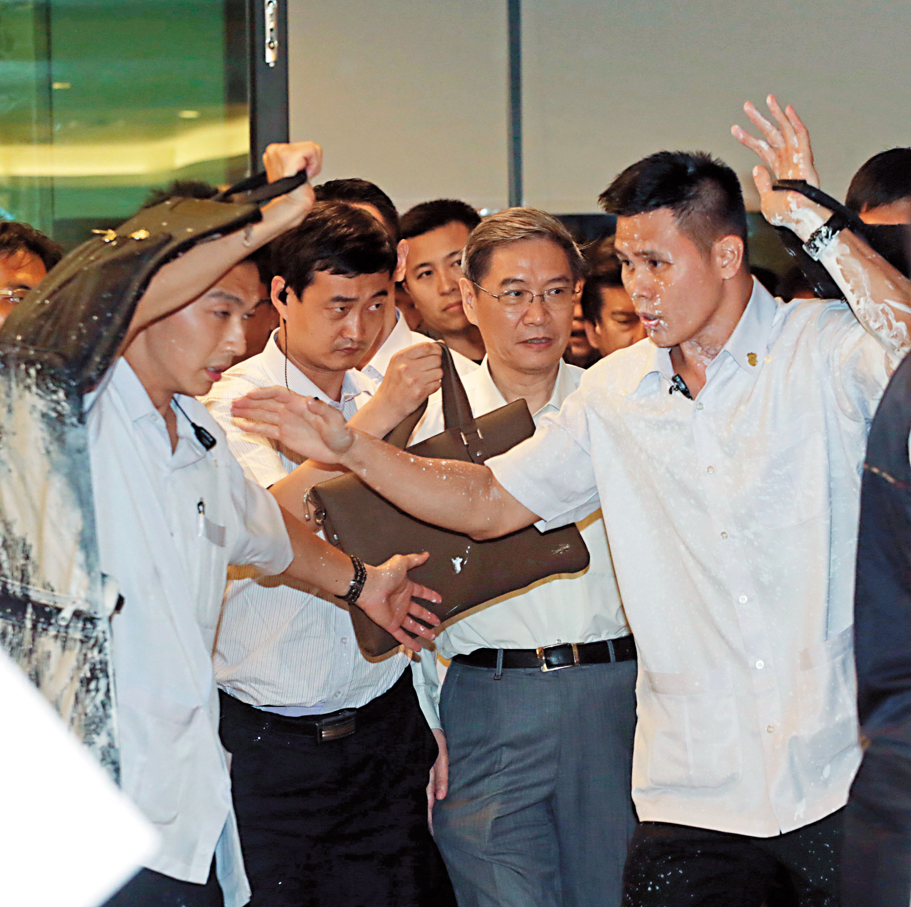 2014年中國國台辦主任張志軍來台，遭抗議民眾潑白漆，張志軍雖毫髮未傷未被波及，但身旁的隨扈則全身被潑滿白漆。（中央社）