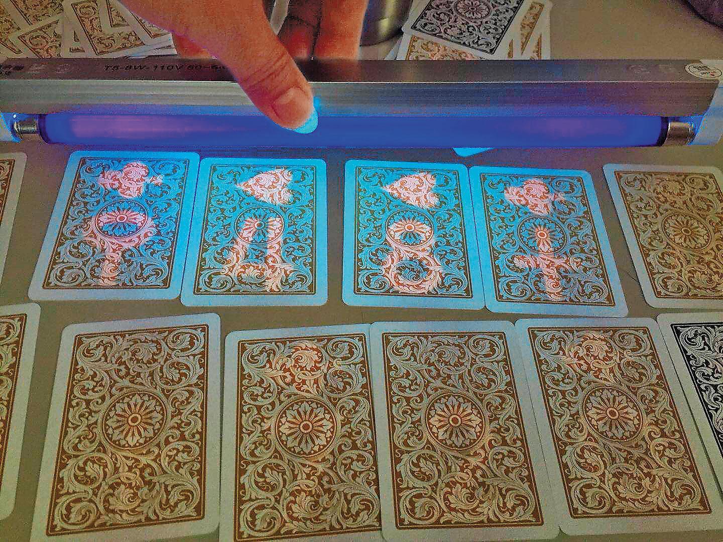 被做了記號的撲克牌,在紫光燈下現形。以這種手法詐賭,難怪外號賭神的QQ,幾乎每把贏錢。