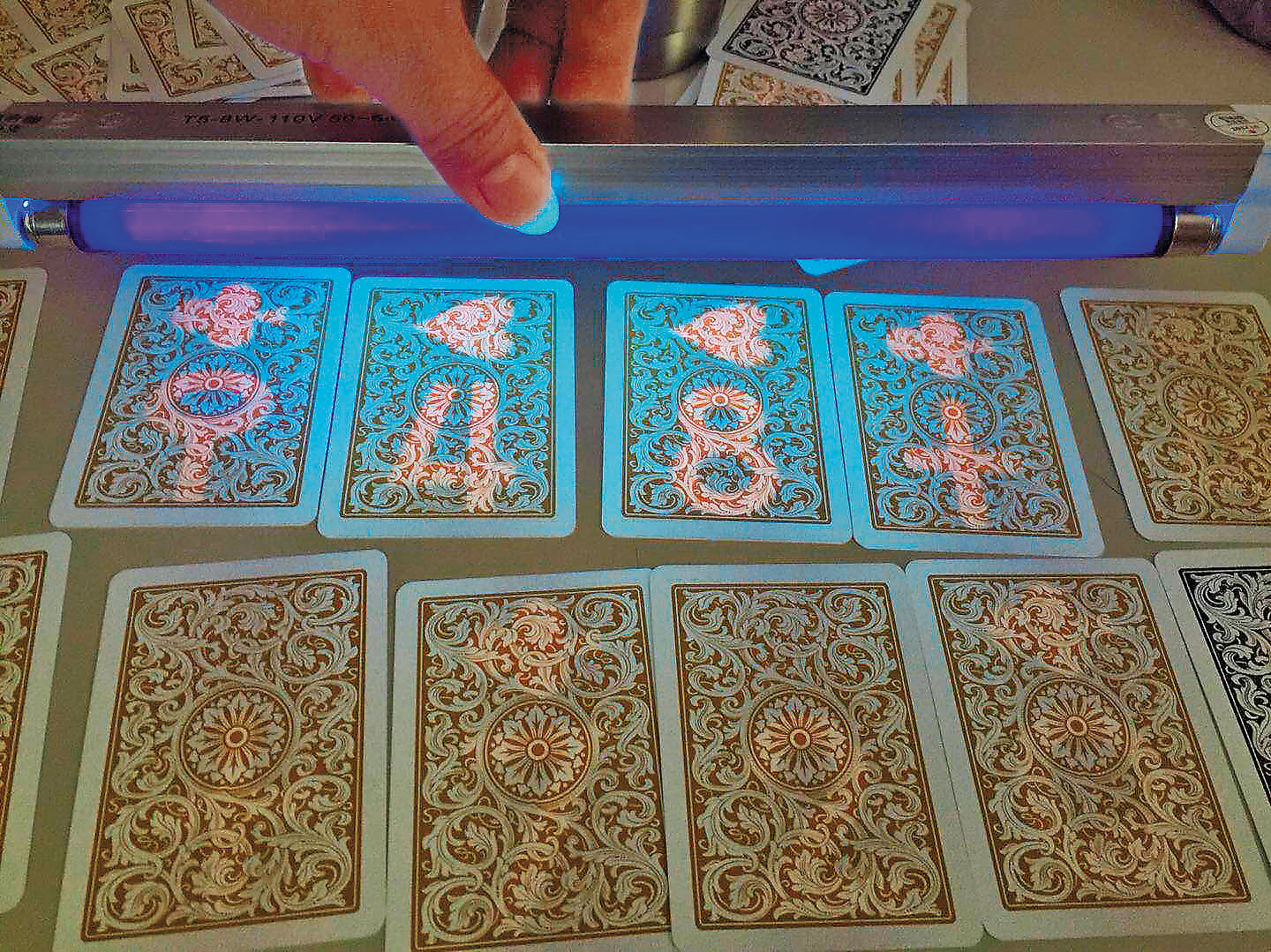 被做了記號的撲克牌，在紫光燈下現形。以這種手法詐賭，難怪外號賭神的QQ，幾乎每把贏錢。